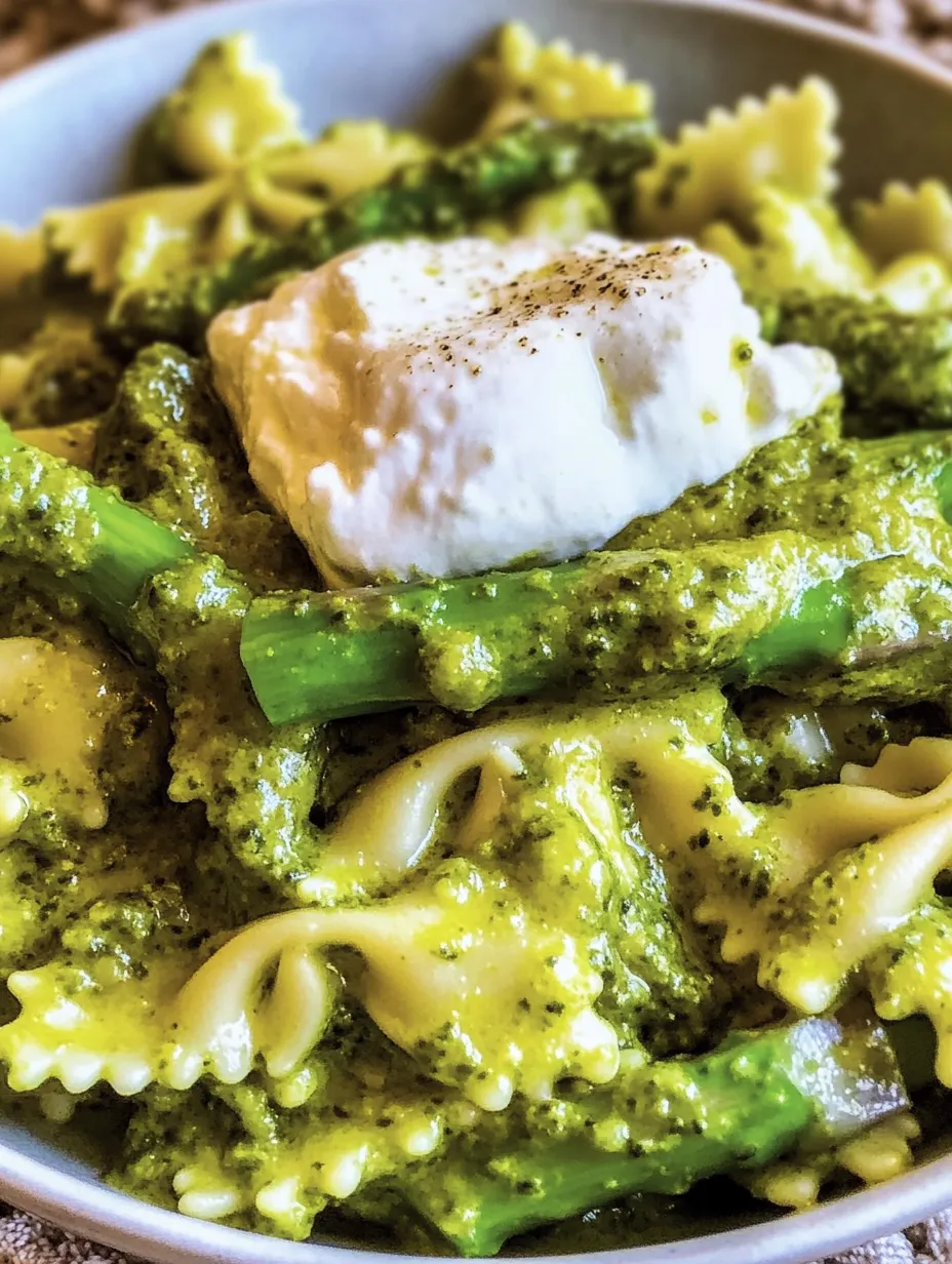 Eine Schüssel mit Pasta, Bärlauchpesto, grünem Spargel und Burrata.