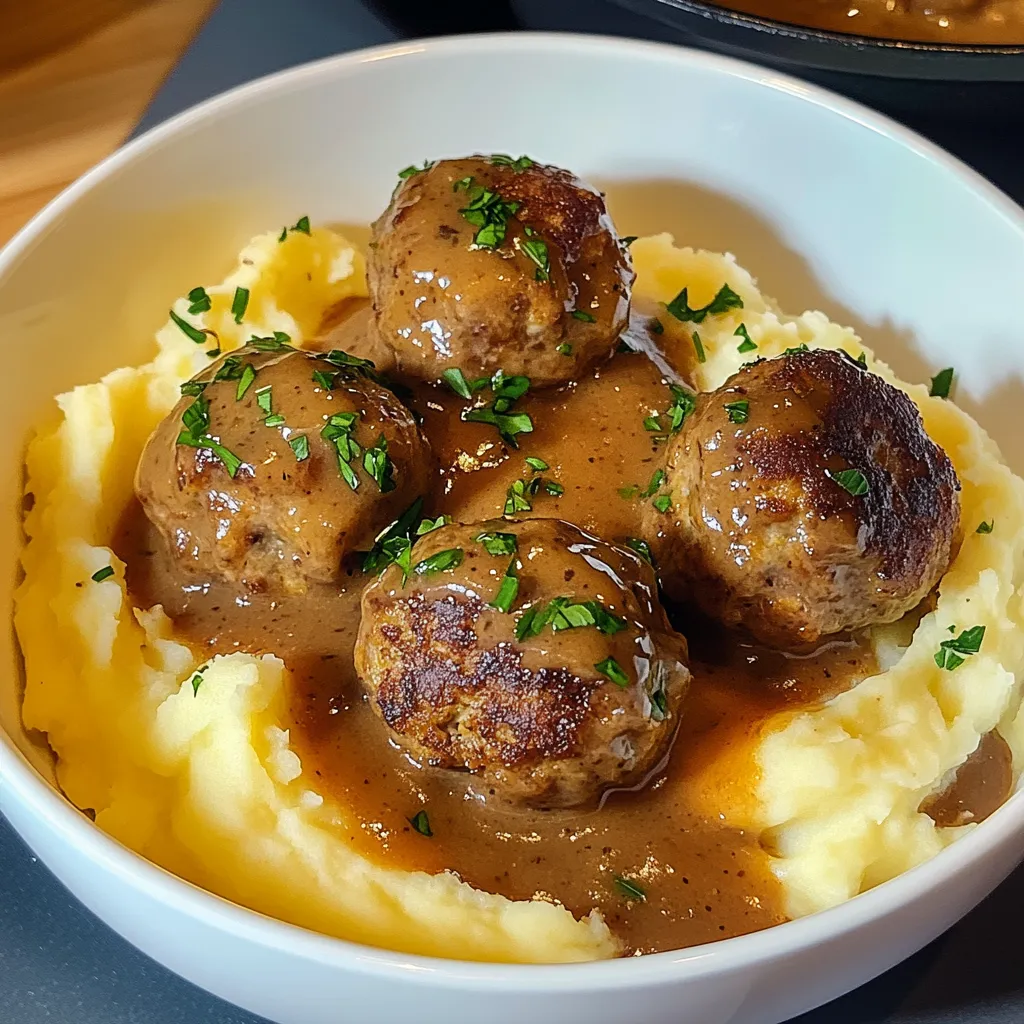 Ein weißer Teller mit Kartoffeln und saurem Fleisch.