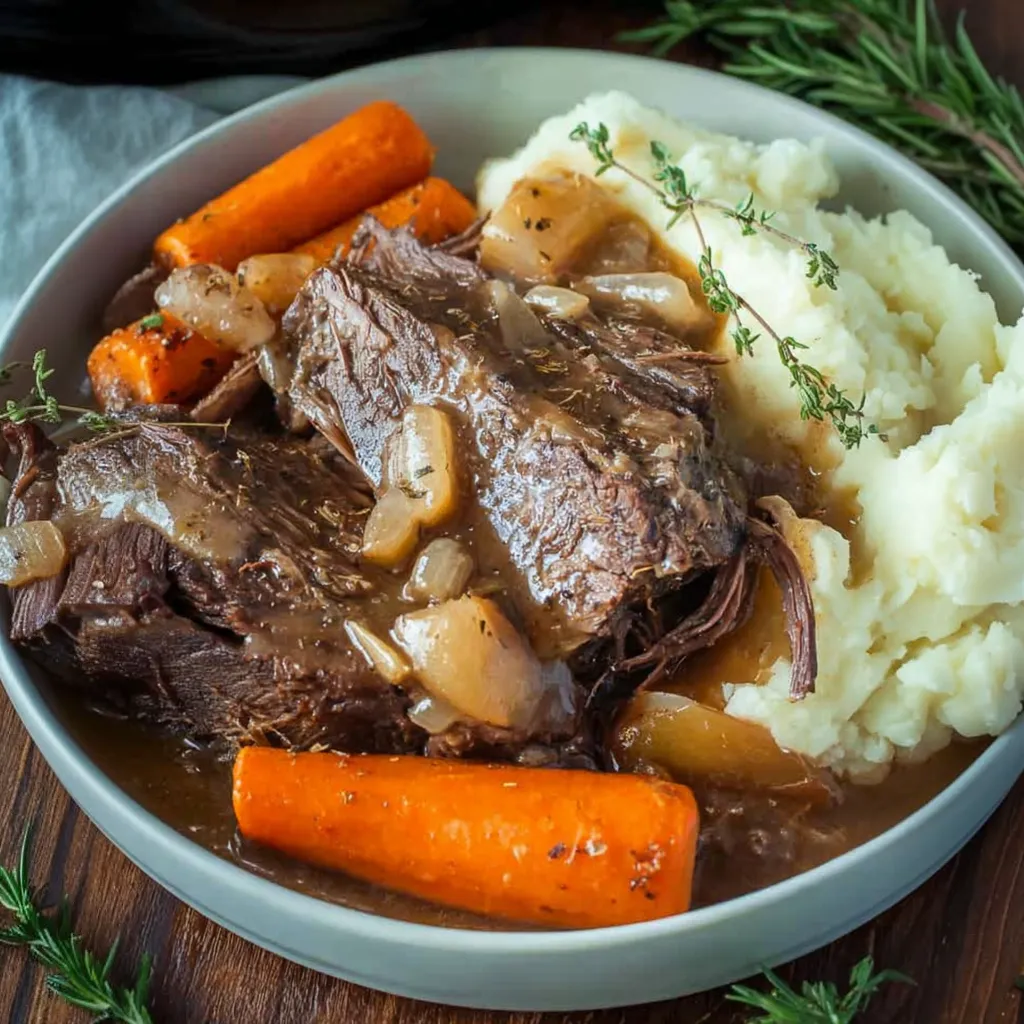 Ein Schüssel mit gegrilltem Fleisch, Kartoffeln, Karotten und anderen Gemüse.