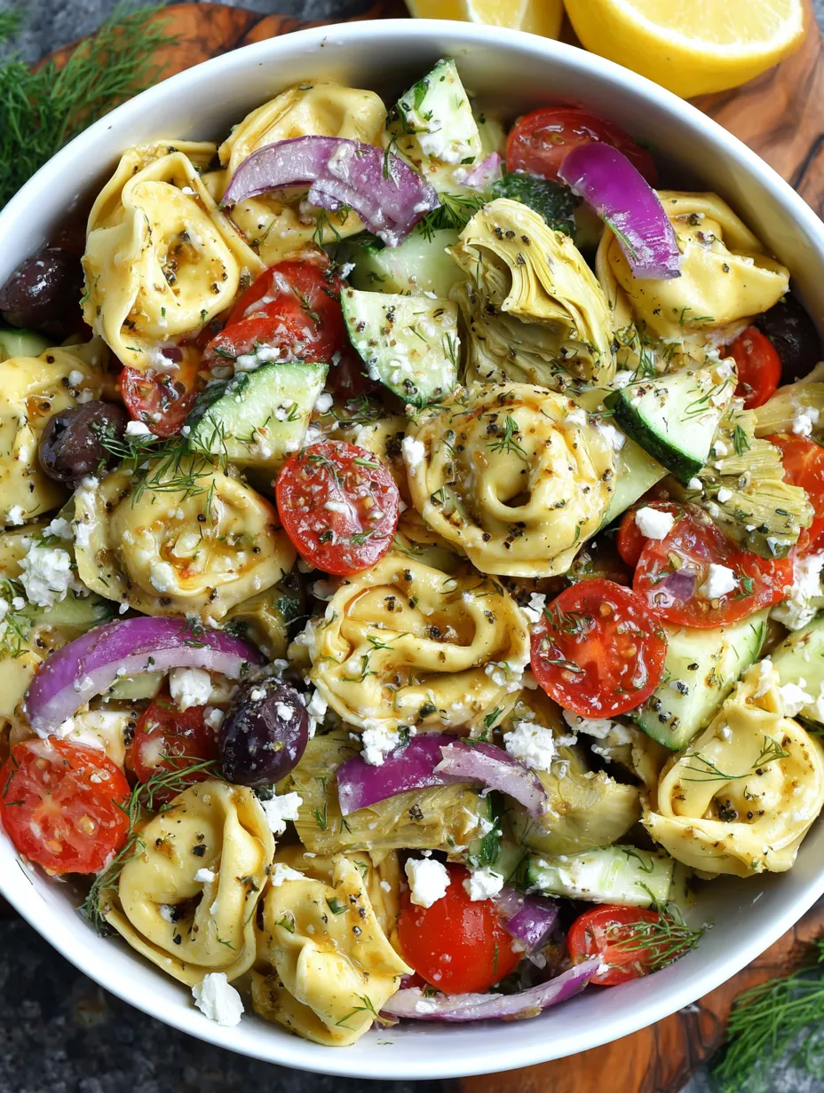Ein weißer Teller mit einer Mischung aus Pasta, Tomaten, Zucchini, Basilikum, Oliven und Garnelen.