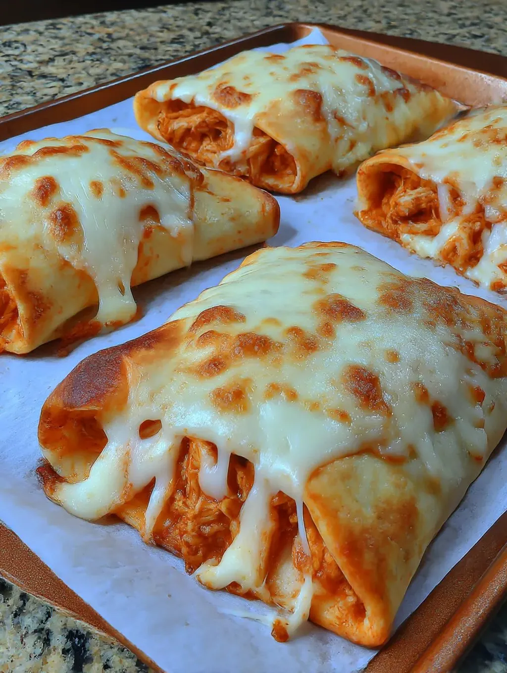 Ein Pizza mit Käse und Chicken auf einer Platte.