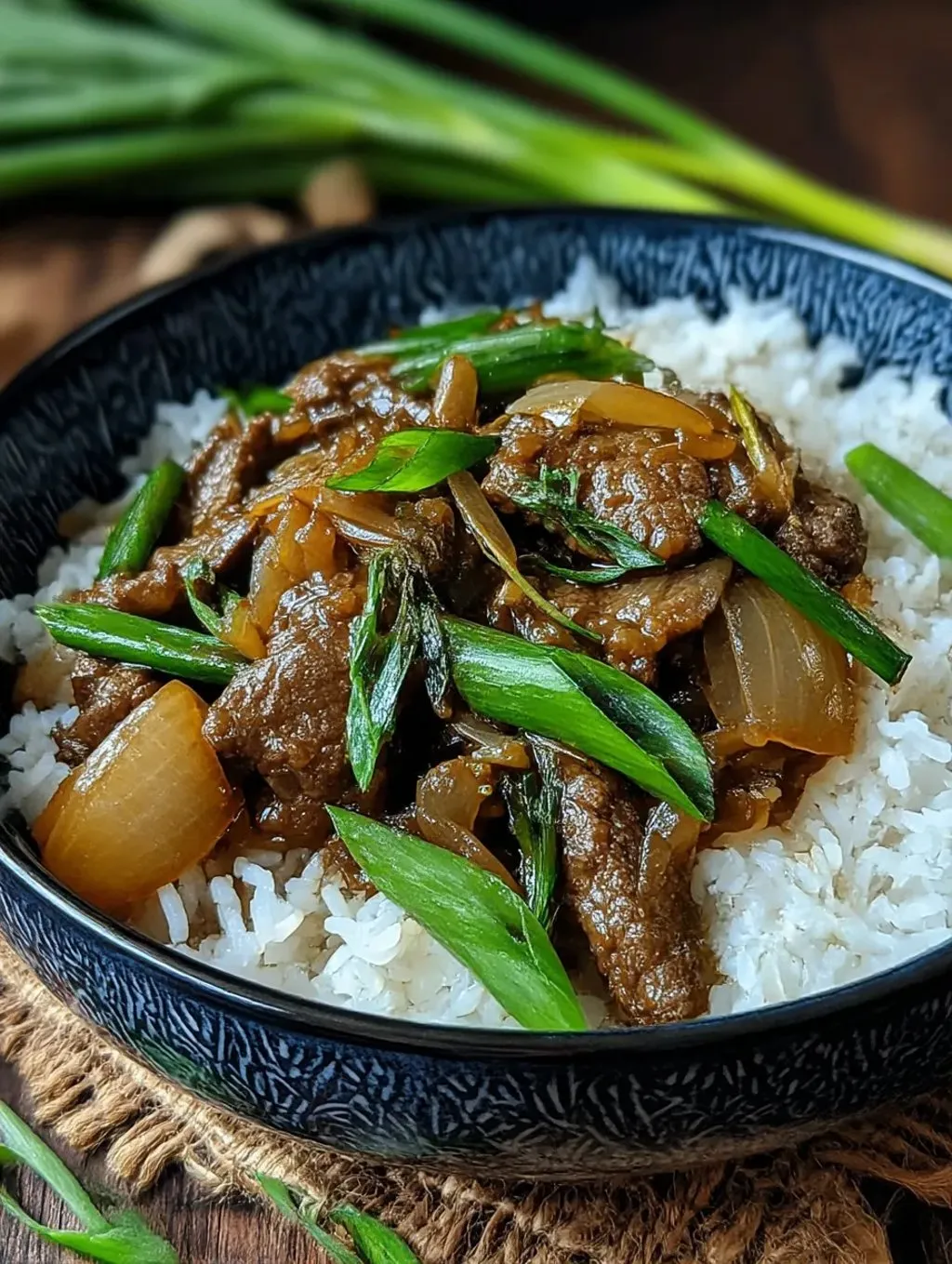Ein schwarzes, glänzendes Bowl mit einer chinesischen Beef and Onion Stir Fry.