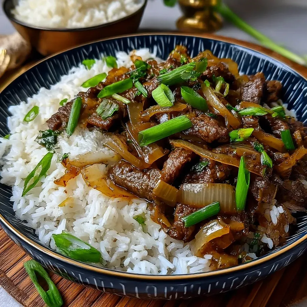 Ein chinesischer Rindfleisch- und Zwiebelstir-Fry mit Reis auf einem Teller.