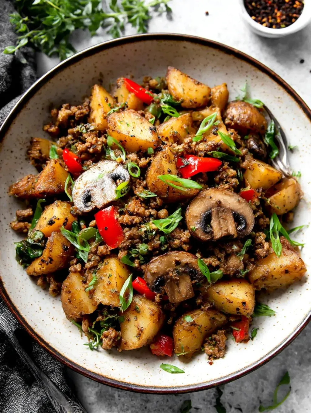 Ein Schälchen mit einer Mischung aus Kartoffeln, Zwiebeln, Tomaten, Möhren, Rindfleisch, Mushrooms und Paprika.