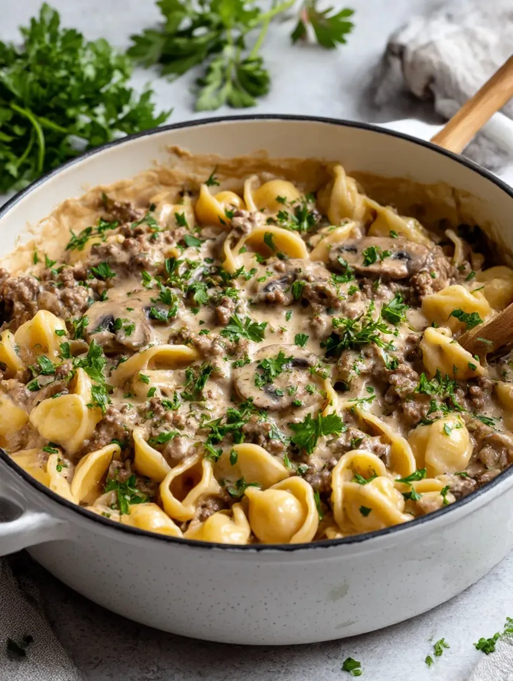 Ein Topf mit einer Mischung aus Nudeln, Beef Stroganoff und Zwiebeln.
