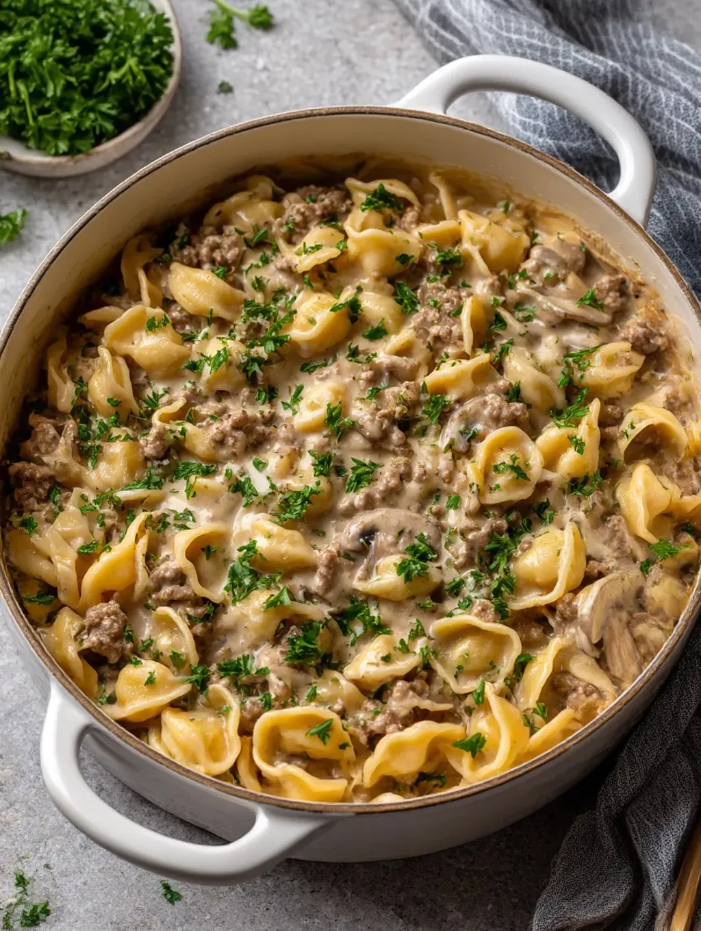 Ein Topf mit einer Mischung aus Nudeln, Beef Stroganoff und Zwiebeln.