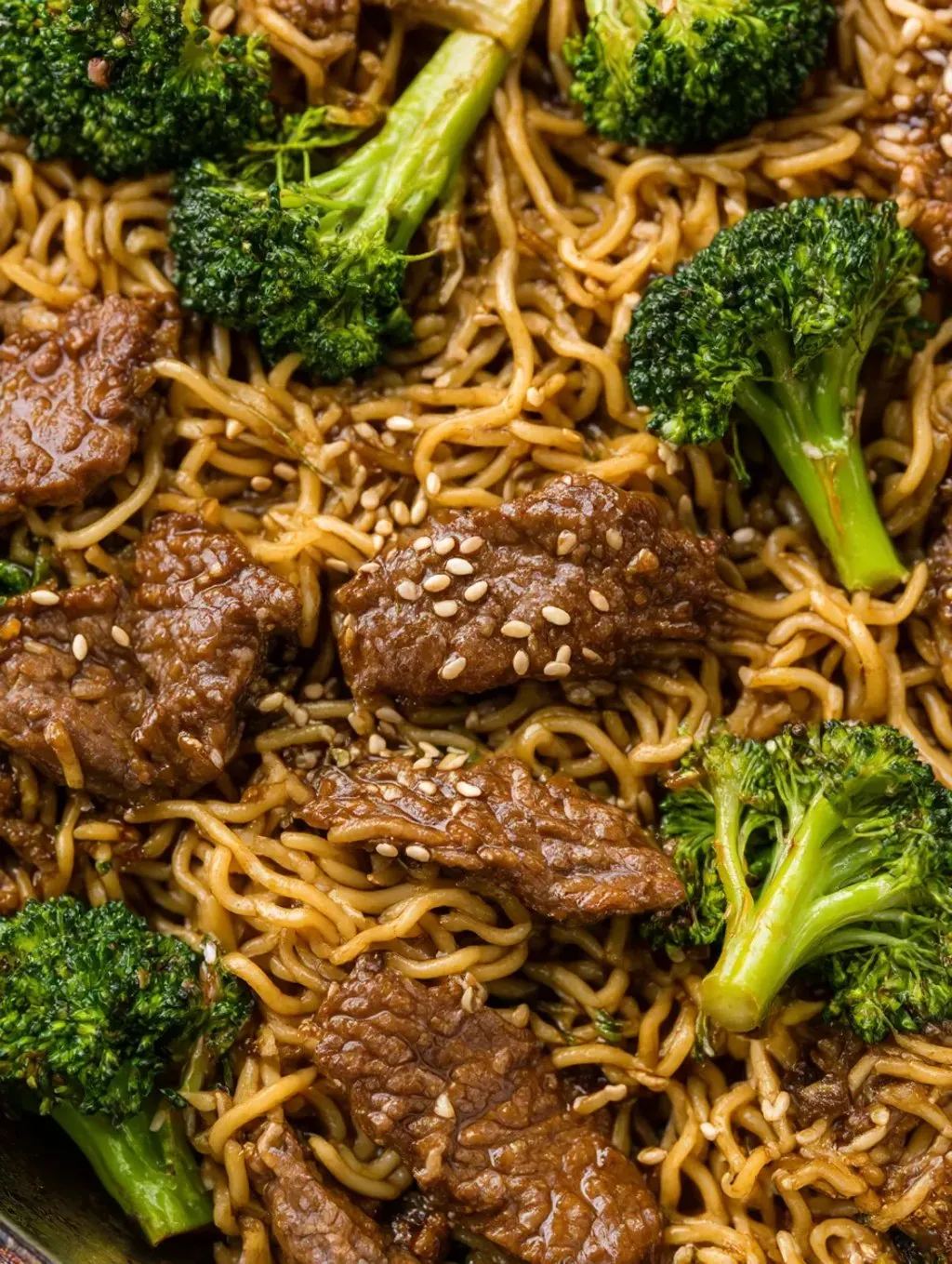 Ein Bild von einer Ramen-Gerichte, die mit Ground Beef und Teriyaki-Sauce zubereitet wurde. Es enthält auch eine Mischung aus Zwiebeln, Broccoli und Kichererbsen.