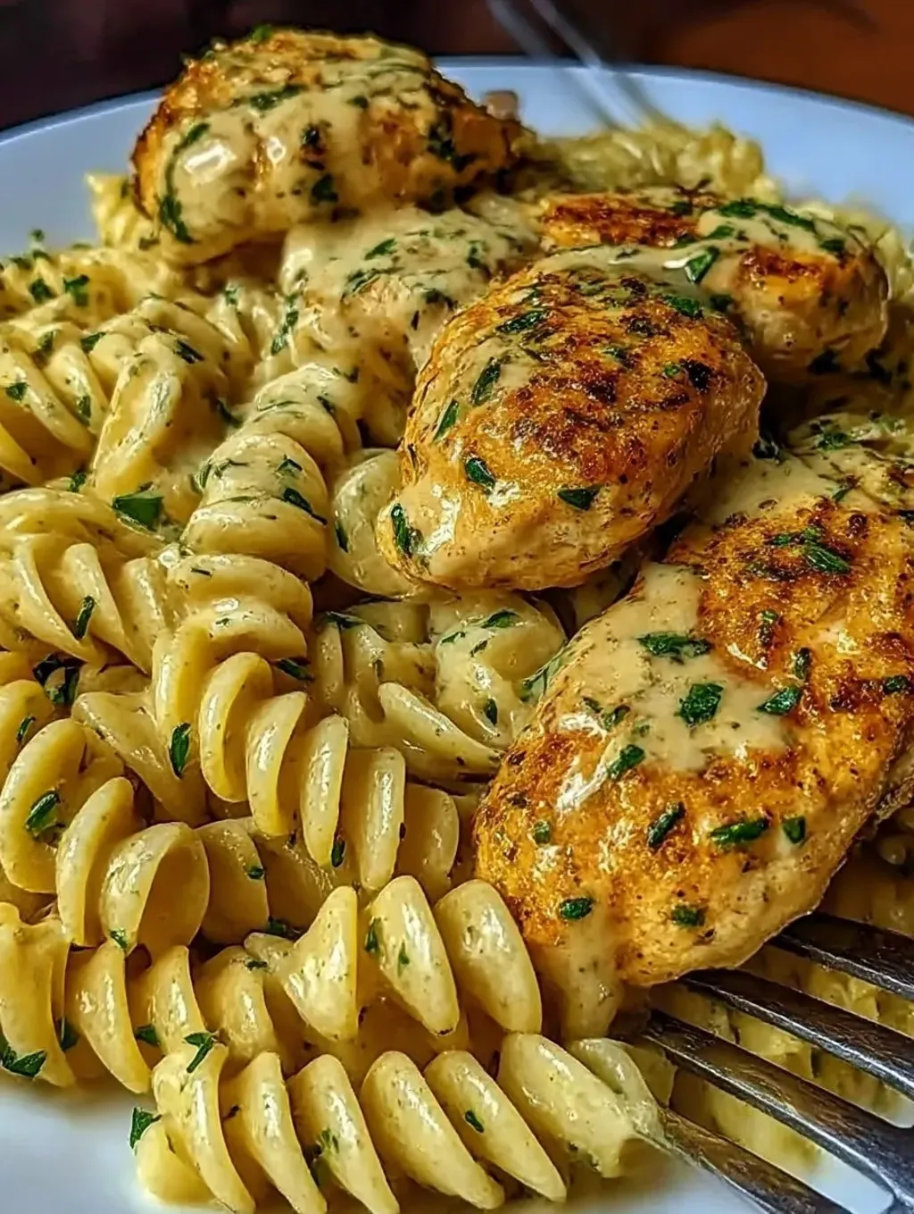 Ein Bild von einer cremigen Garlic Parmesan Chicken mit Cheesy Twisted Pasta.