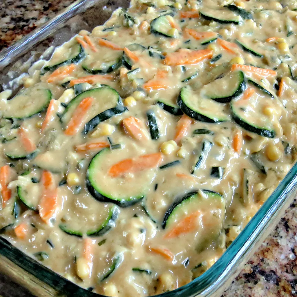 Ein Glas mit Zucchini-Korn-Casserole, die mit Zucchini, Korn und Käse zubereitet wurde.