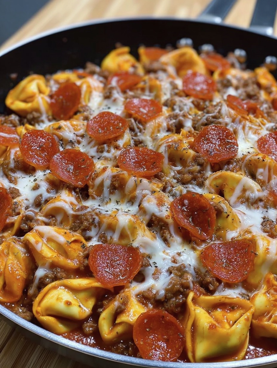 Eine Schüssel mit Pizza, die aus Ravioli, Käse und Tomaten besteht.
