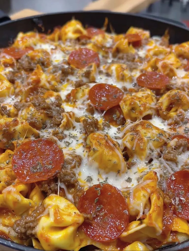 Eine Pizza mit Pasta, Tomaten, Mozzarella und Pepperoni.
