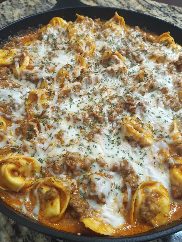 Eine Schüssel mit Pasta, die mit Käse und Zwiebeln garniert ist.