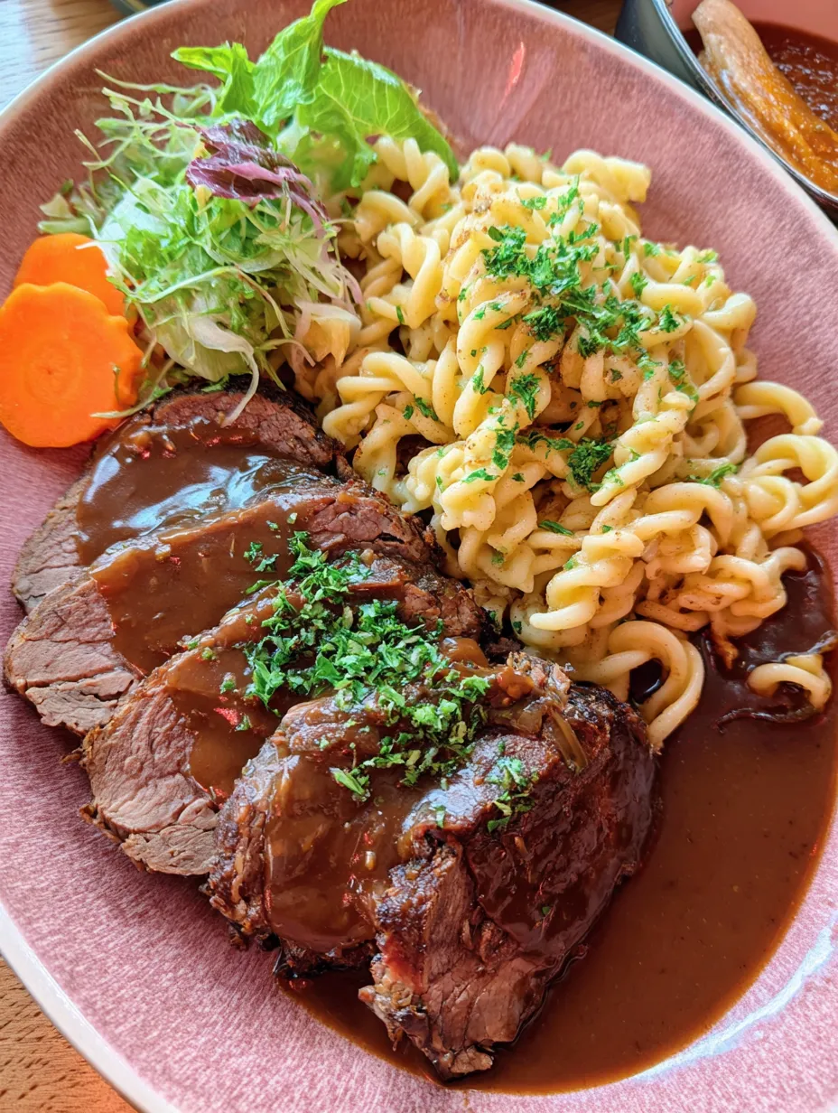Ein Plate mit Rindfleisch, Pasta, Salat und Sauce.