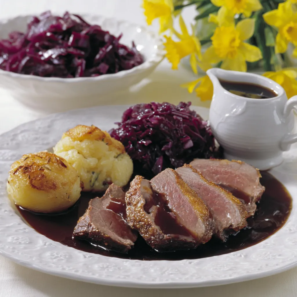 Ein Teller mit Fleisch, Kartoffeln und Sauce.