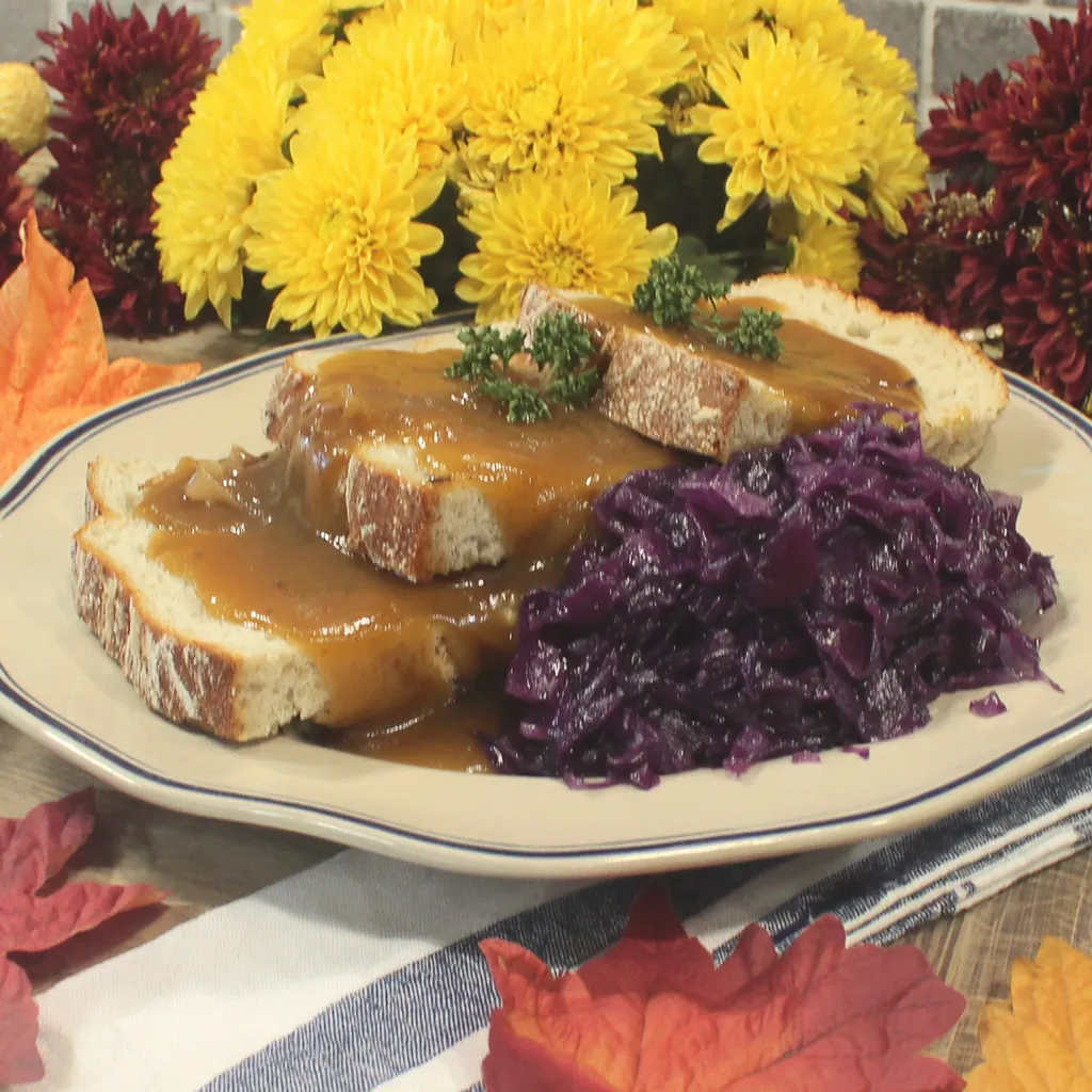 Ein weißer Teller mit einer Mischung aus Sauerkraut, Kartoffeln und Sauce.