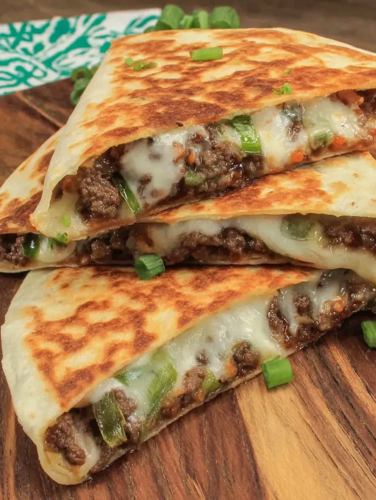 Eine Schicht aus Käse und Rindfleisch auf einer Tortilla.