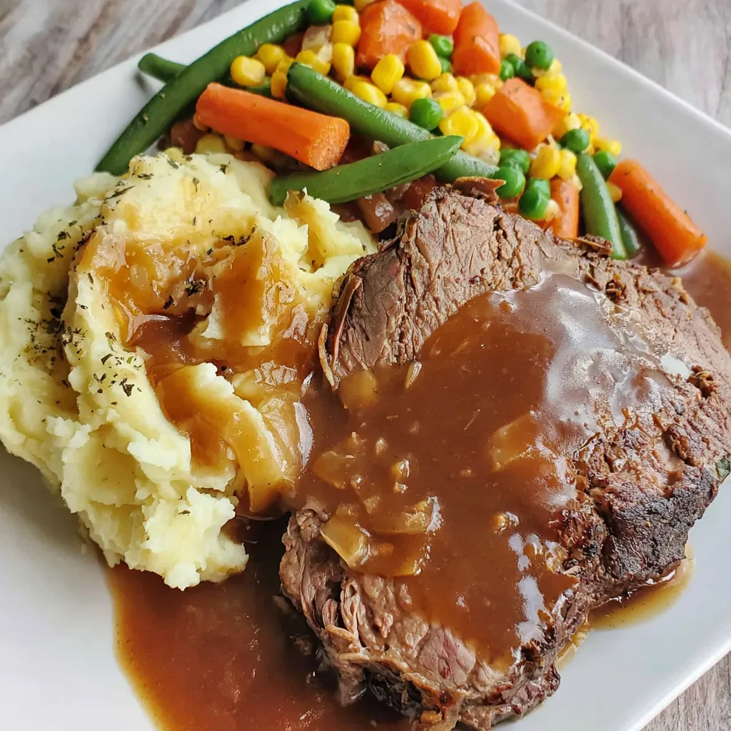 Ein Plate mit Steak, Kartoffeln, Karotten, Kohl und Sauce.