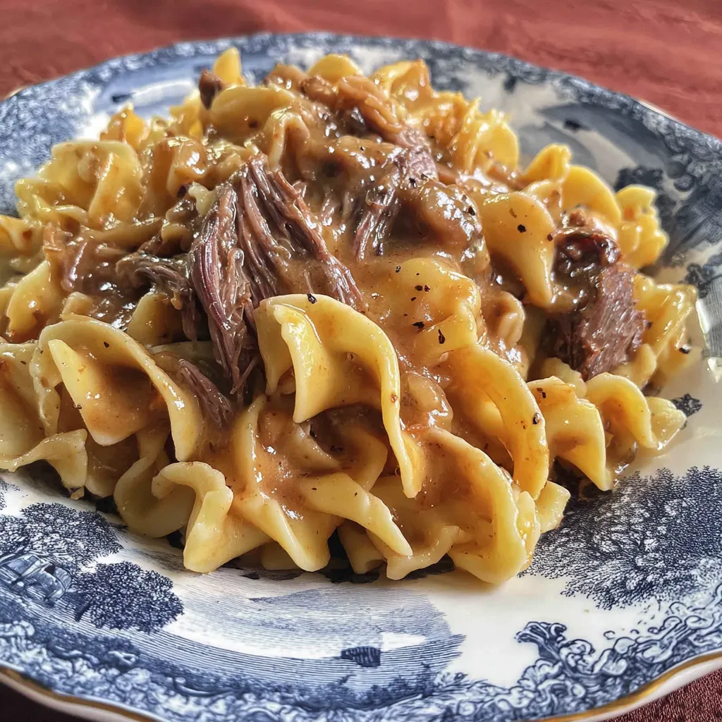 Ein Plate mit Pasta und Fleisch.