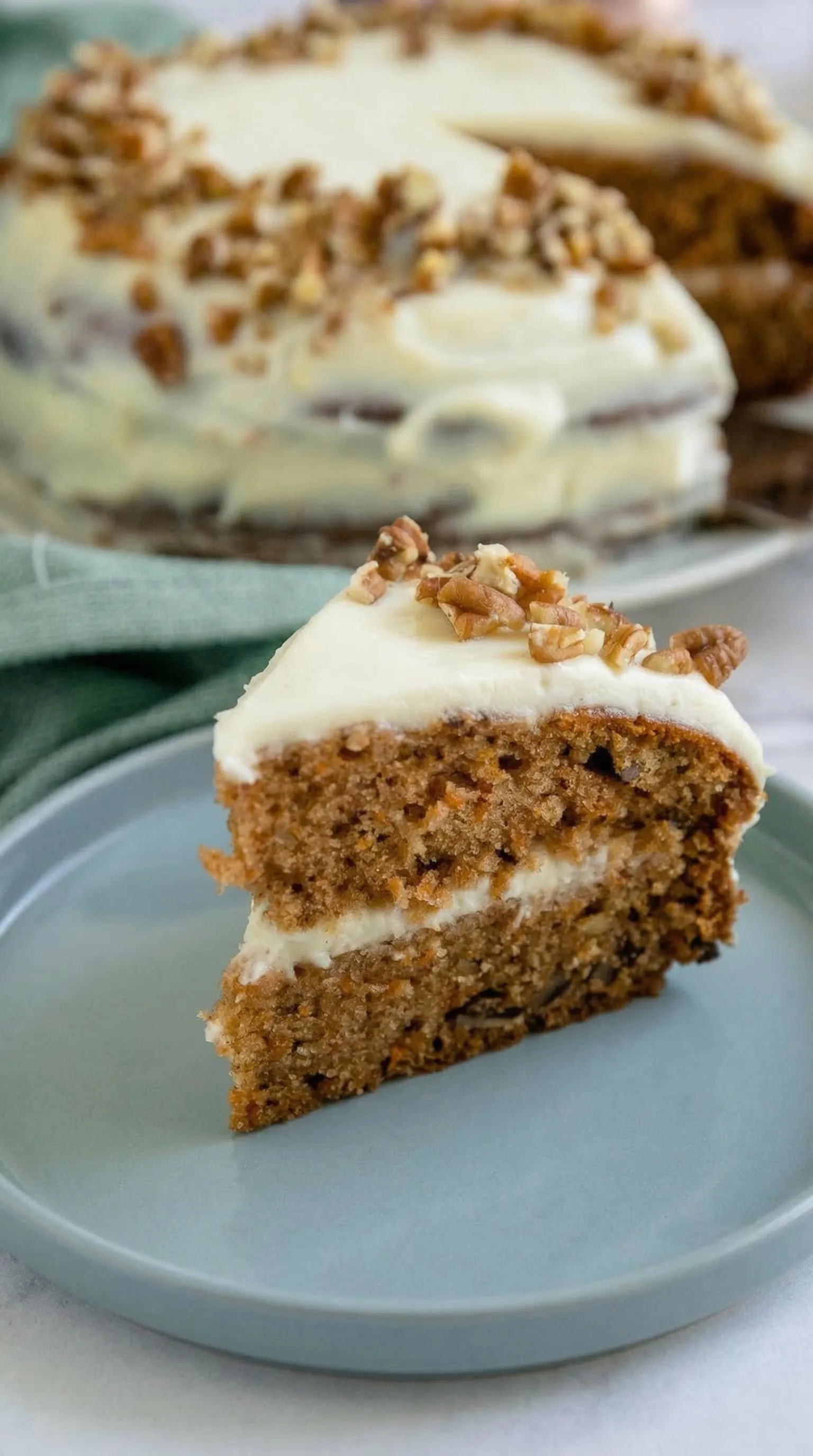 Ein Stück Carrot Cake mit Frischkäse auf einem Plate.