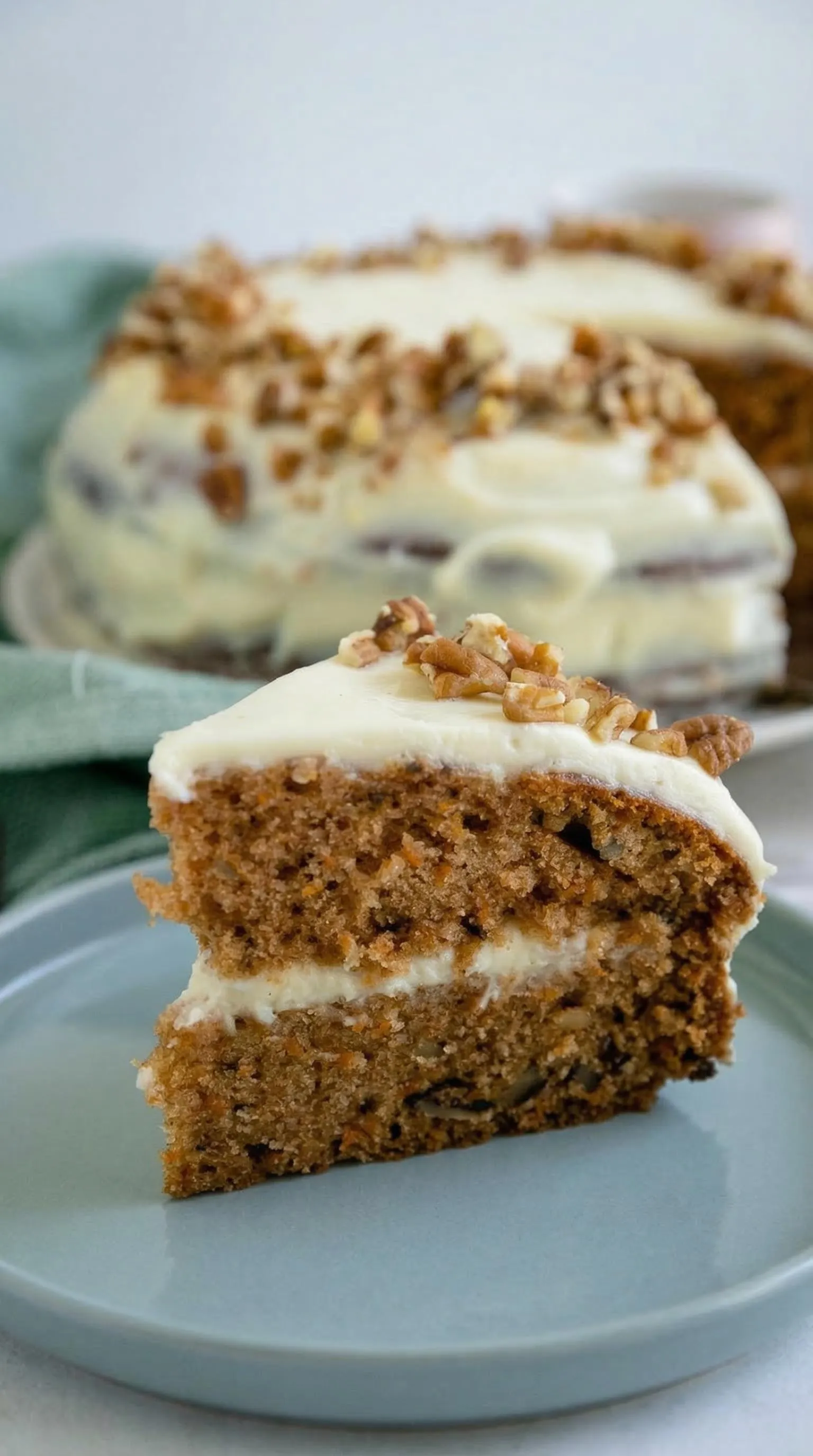 Ein Stück Carrot Cake mit Frischkäse auf einem Plate.
