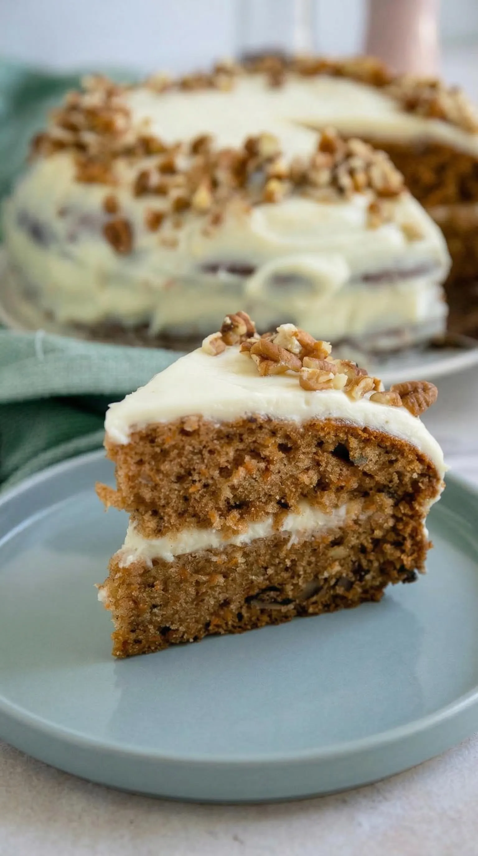 Ein Stück Carrot Cake mit Frischkäse auf einem Plate.