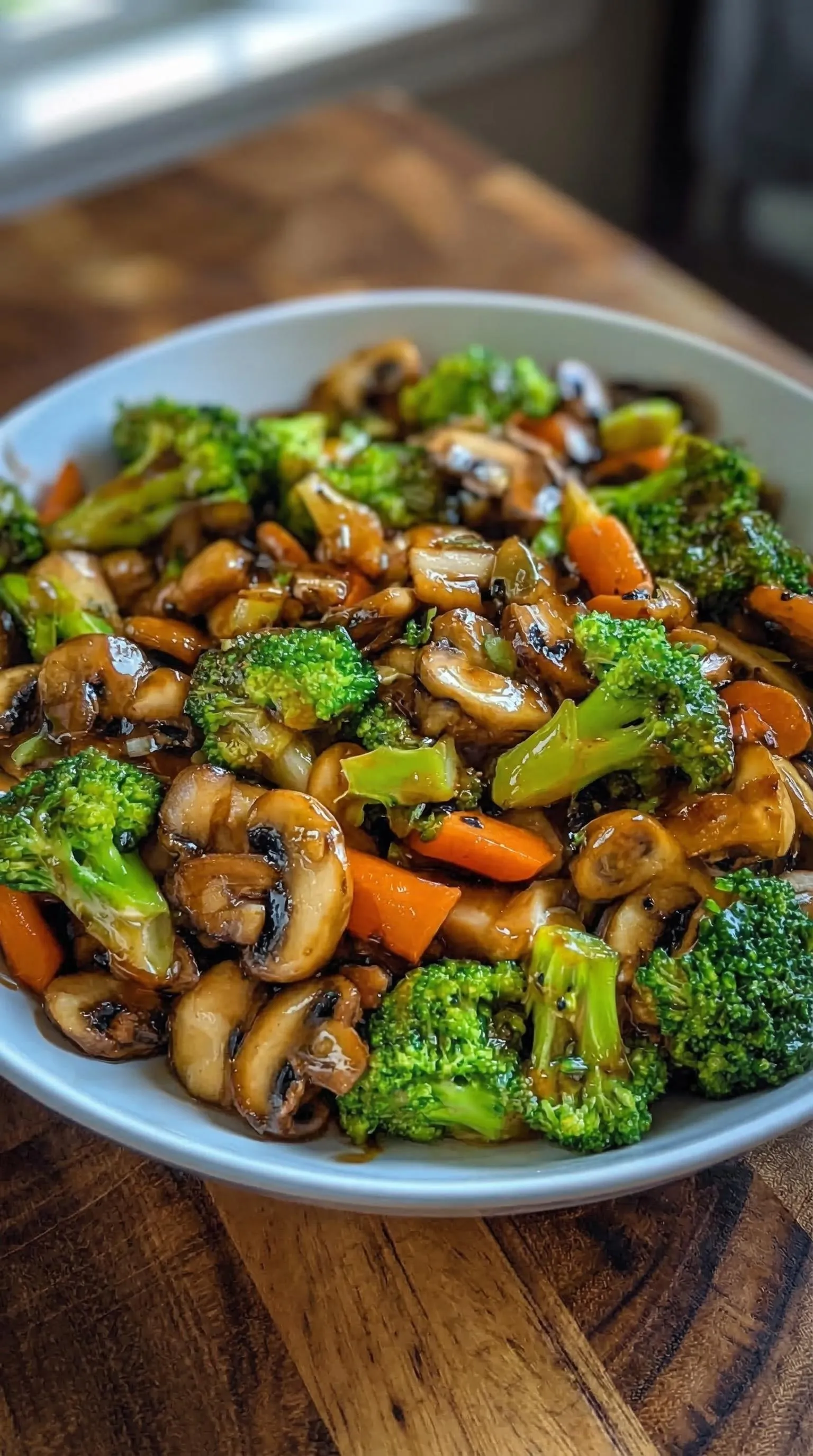 weißer Teller mit einer Mischung aus Champignons, Brokkoli und Karotten.