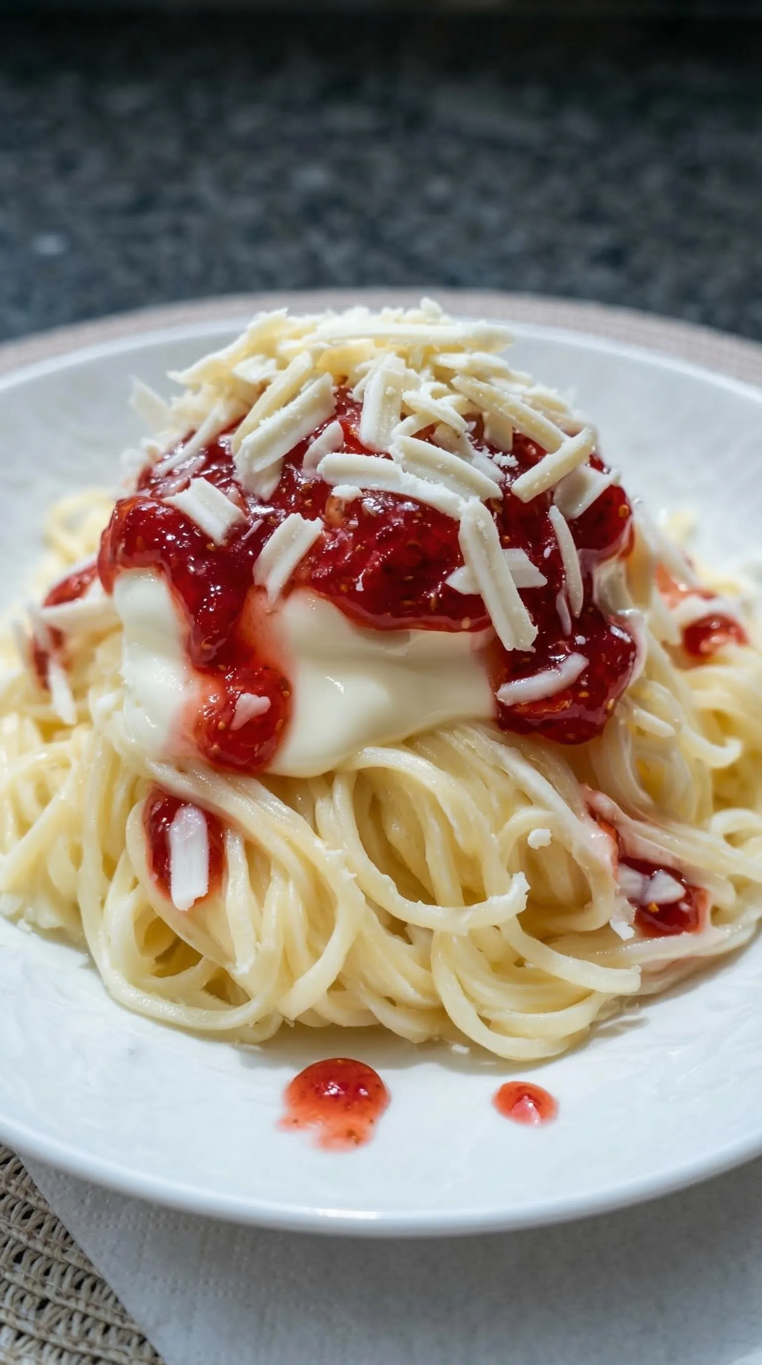 Ein Plate mit Spaghetti und Tomaten.