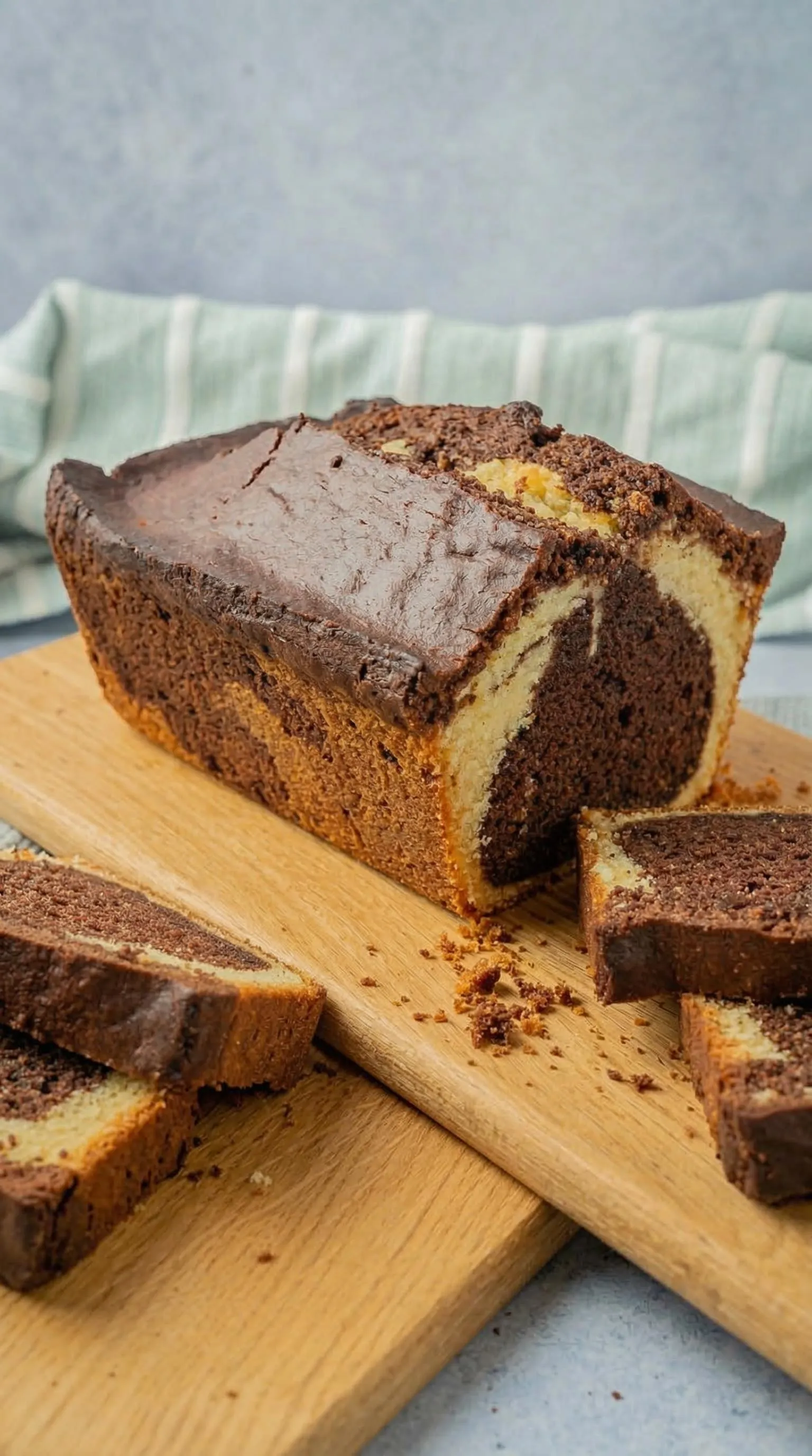 Ein Marmorkuchen aus der Kastenform auf einem Holzbrett.
