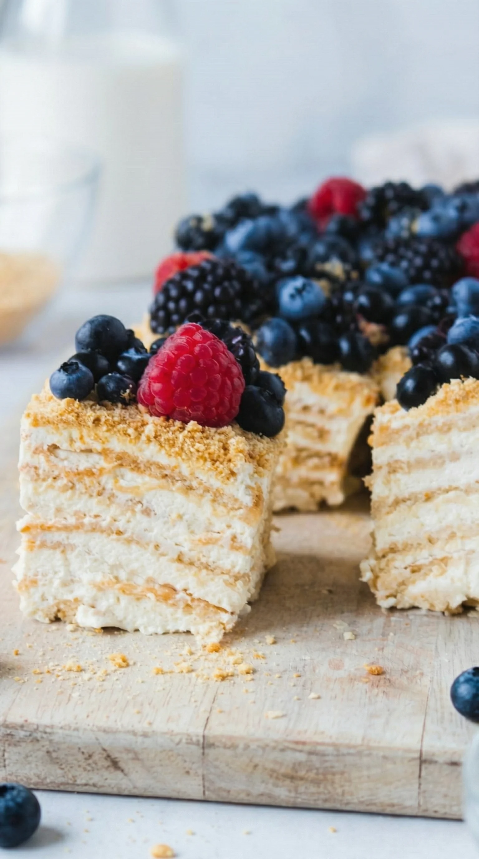Ein Milchmädchenkuchen mit Raspberry-Raspe und Blaubeeren auf einem Tisch.