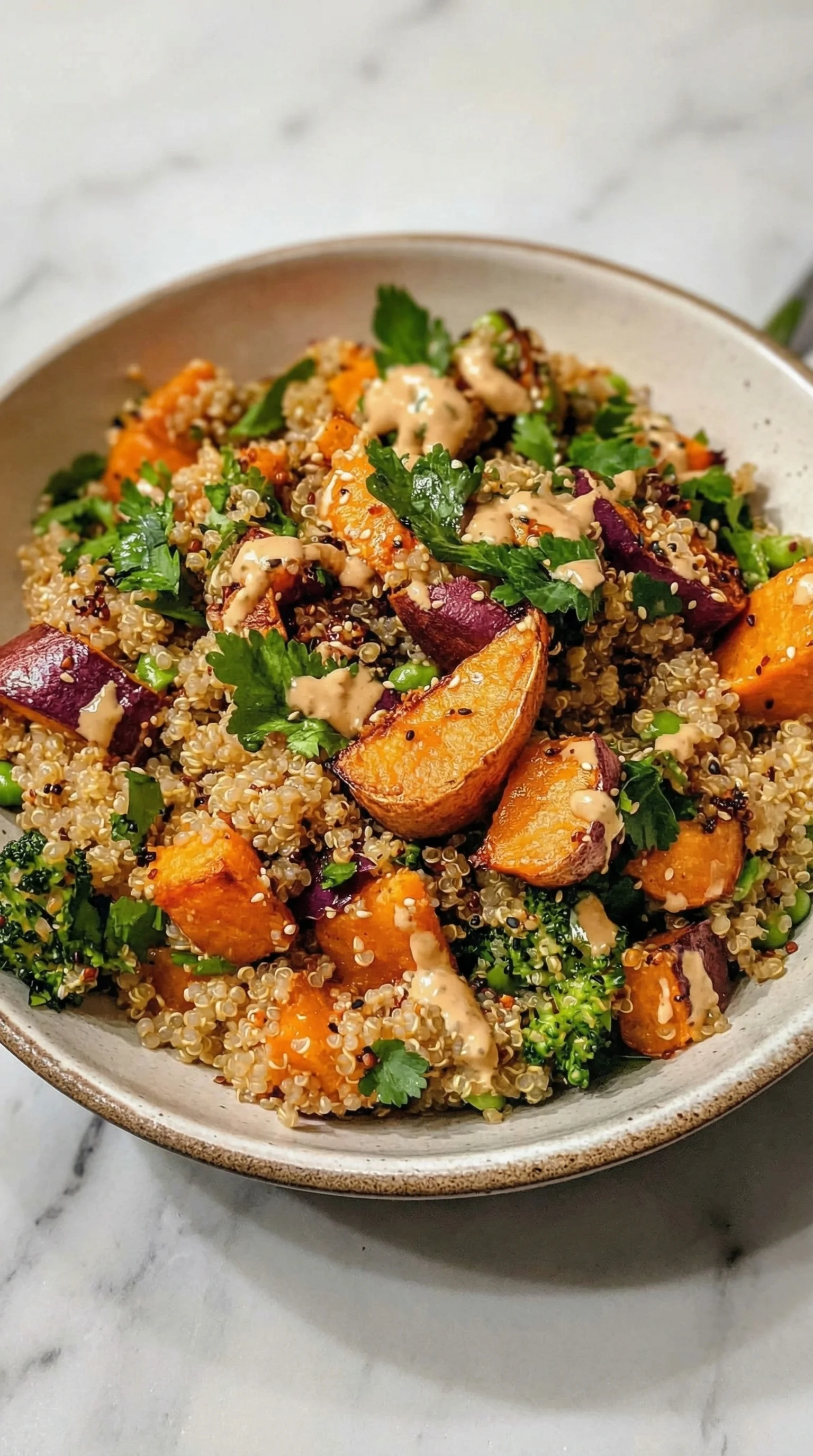 Ein Gerösteter Süßkartoffel-Quinoa-Salat mit Sesam-Miso-Sauce in einem weißen Behälter.