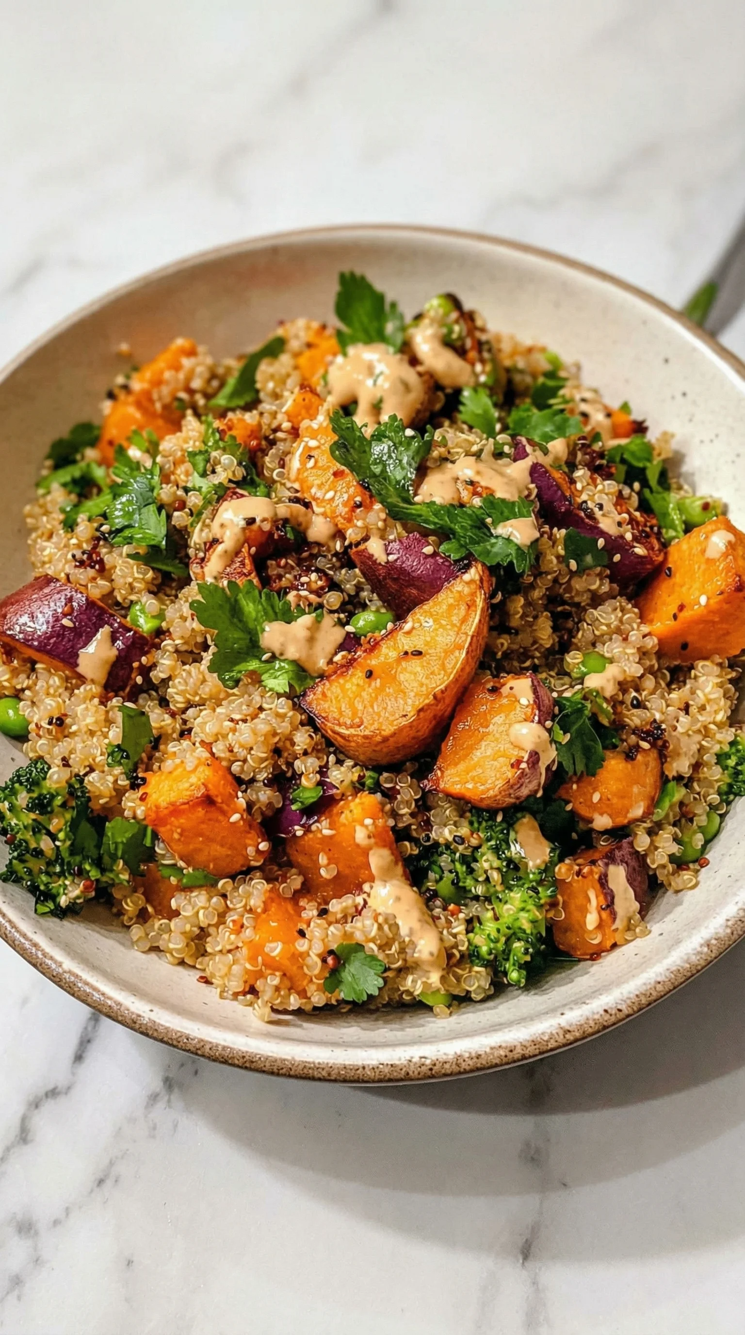 Ein Gerösteter Süßkartoffel-Quinoa-Salat mit Sesam-Miso-Sauce in einem weißen Teller.