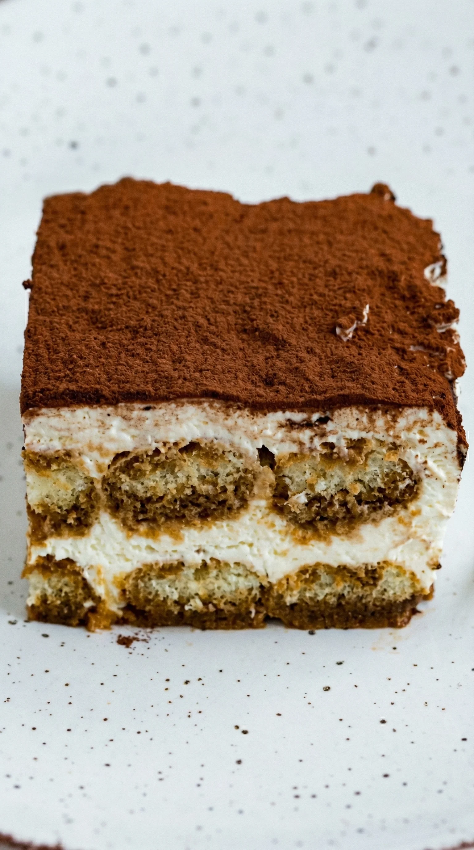 Ein Stück Tiramisu nach italienischer Art, das in Schichten aufgeteilt ist.