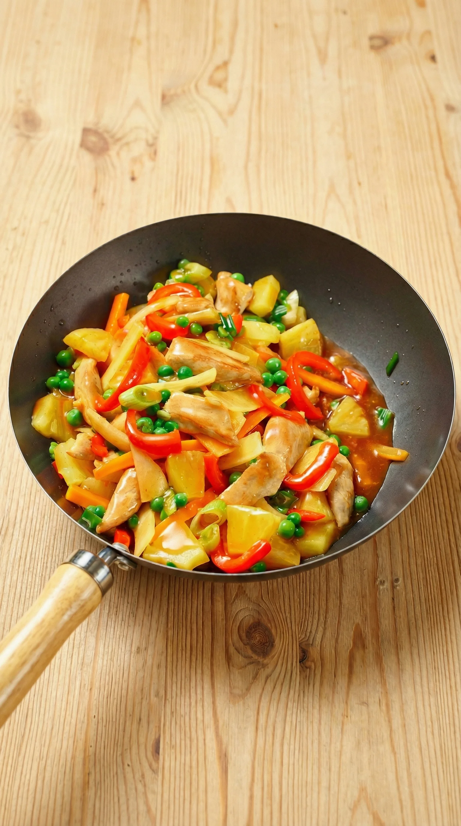 Ein Wok mit Hähnchen und Ananas.