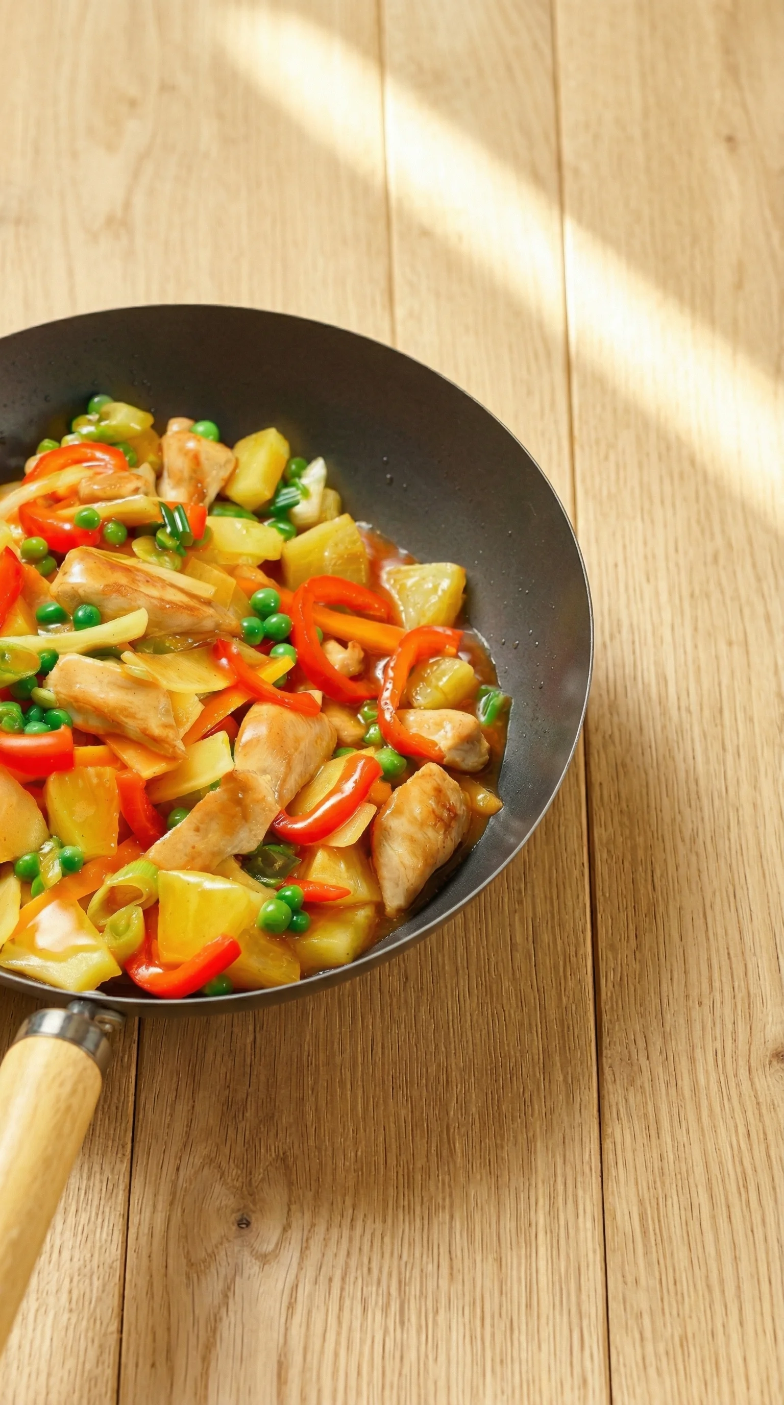 Ein Wok mit Hähnchen und Ananas.