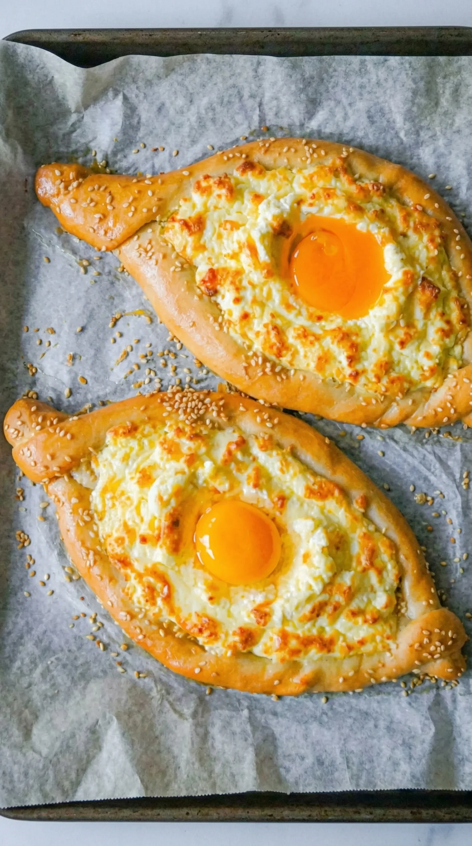 Ein Khachapuri, ein traditionelles georgisches Käsebrot, mit einem Ei in der Mitte.