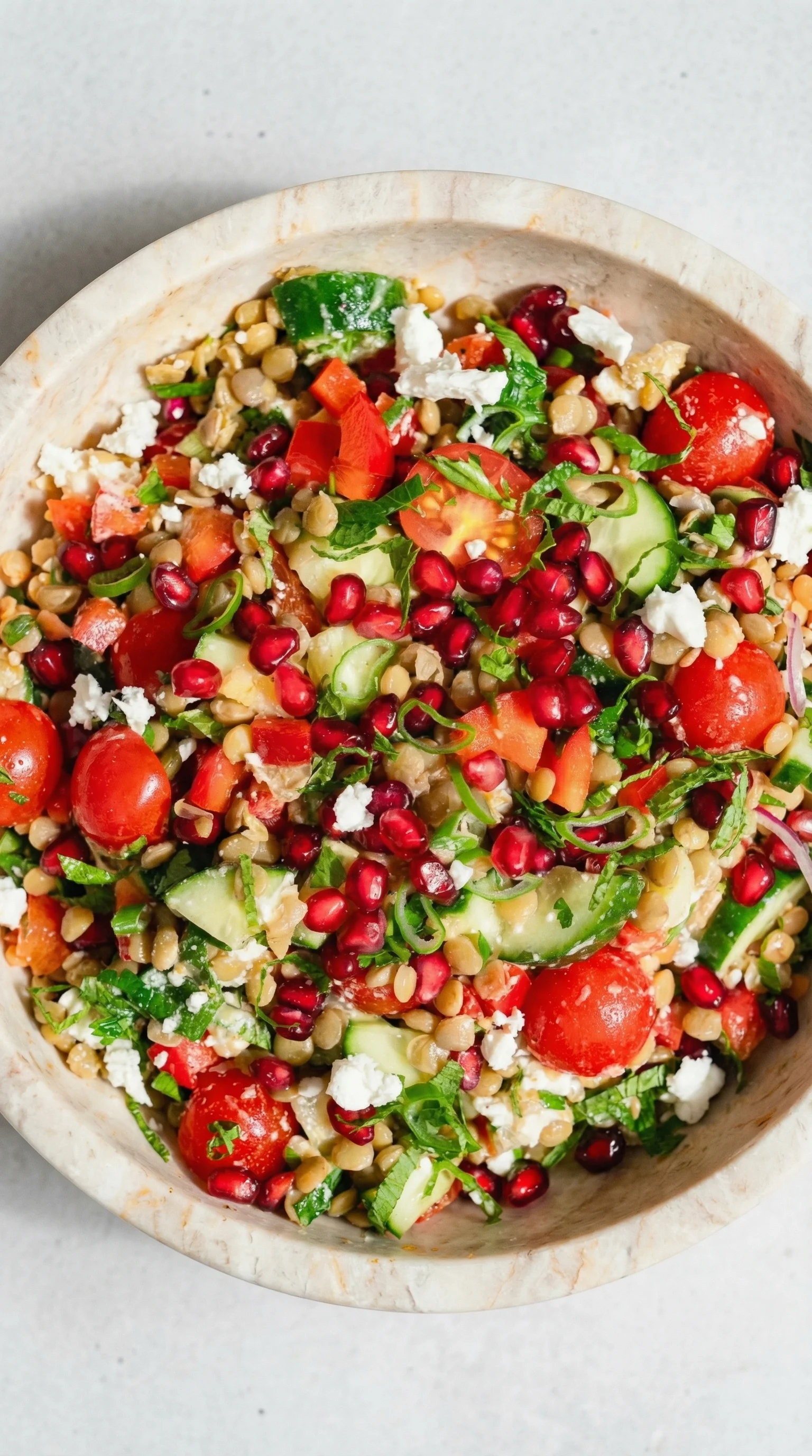 A bowl of salad with tomatoes, cucumbers, and feta cheese.