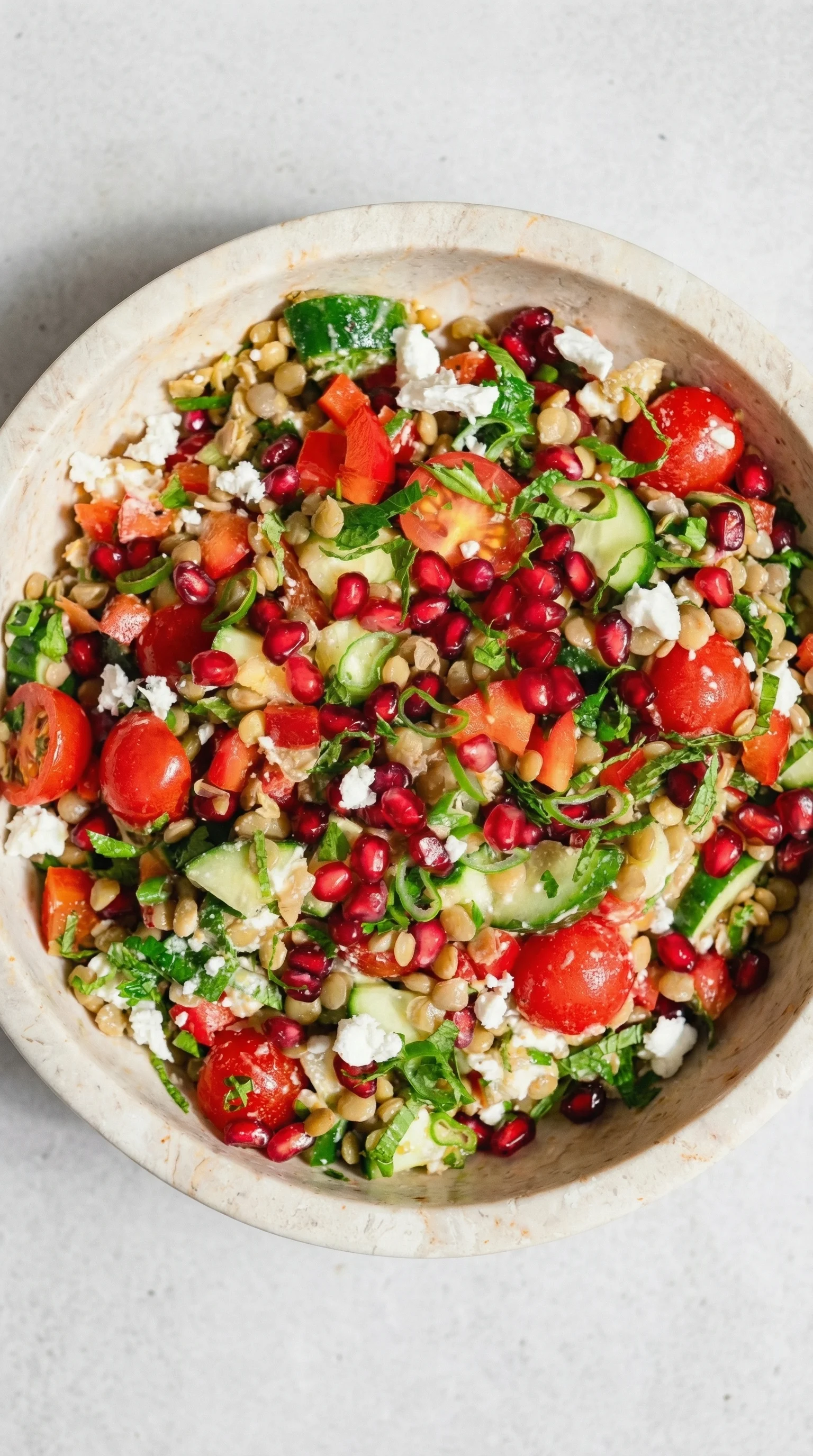 A bowl of salad with tomatoes, cucumbers, and feta cheese.