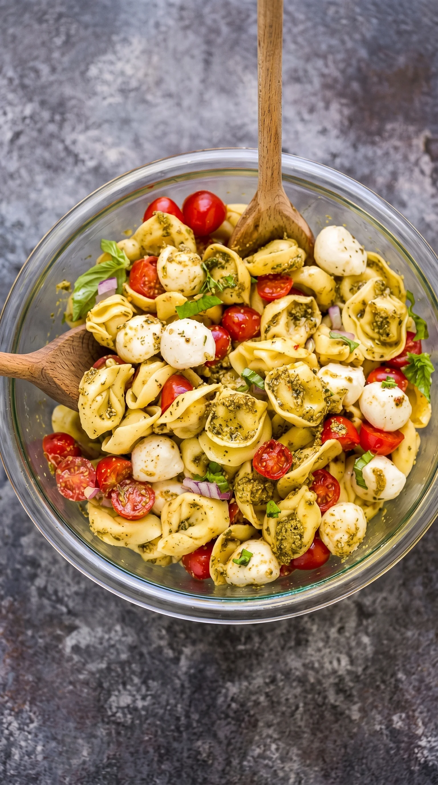 A bowl of pasta with tomatoes and basil.