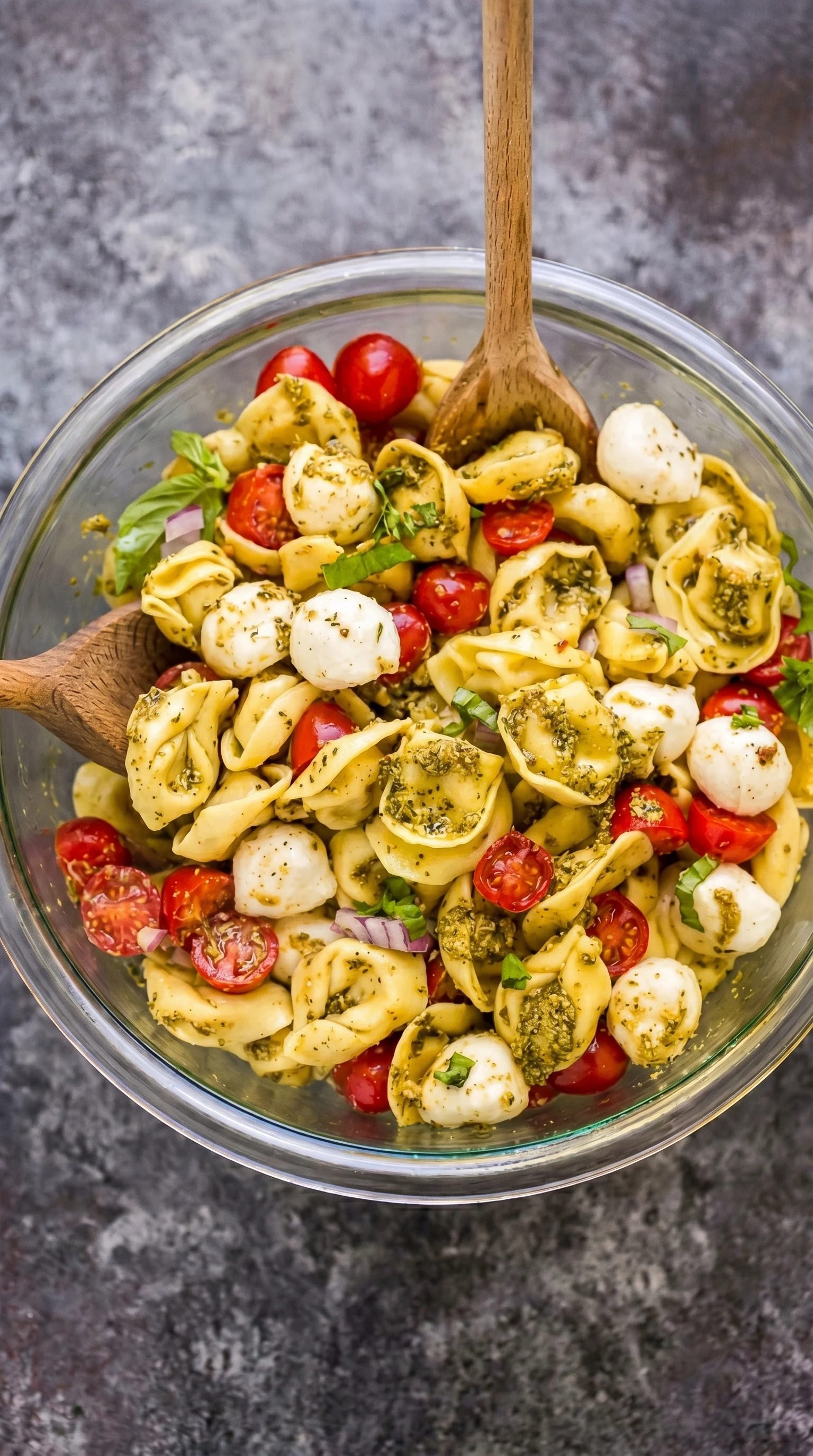 A bowl of pasta with tomatoes and basil.