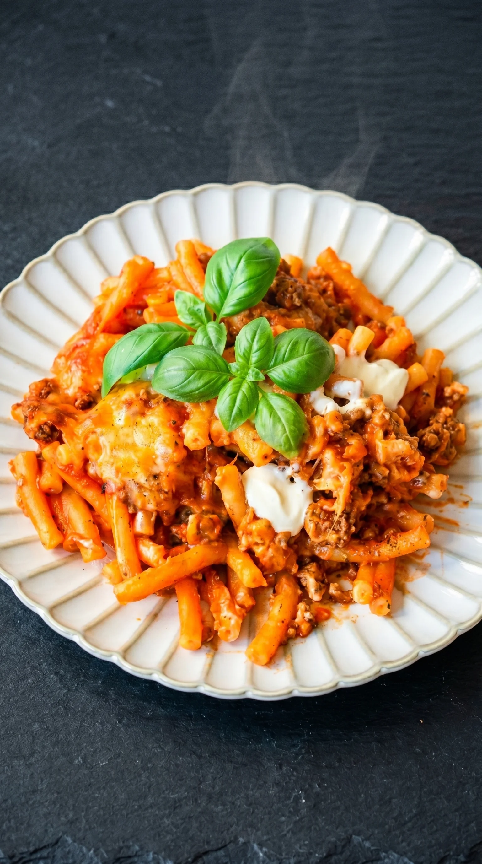 A plate of pasta with cheese and spinach.