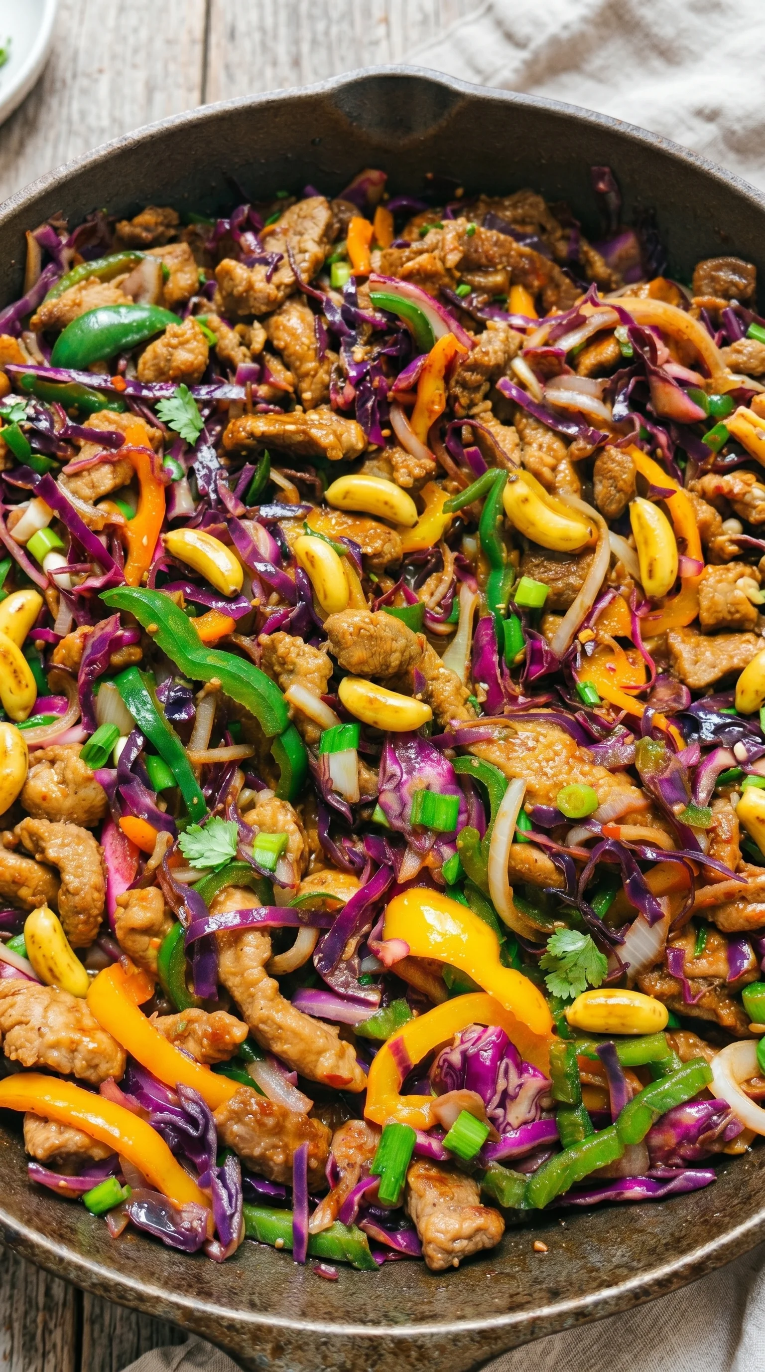 A dish of meat and vegetables, including peppers and onions.