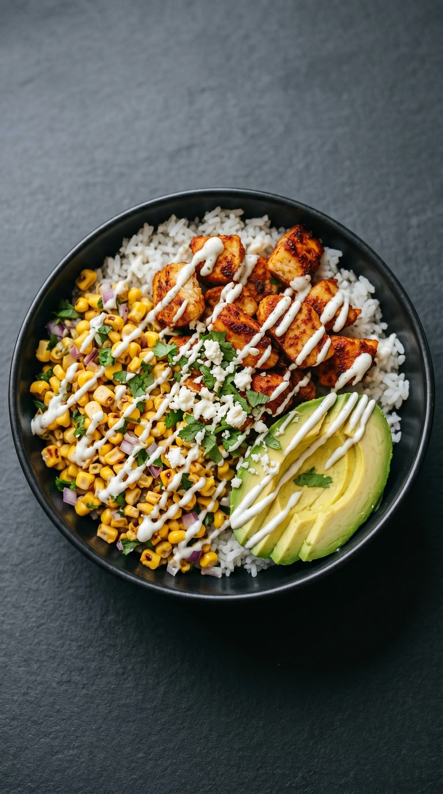 A bowl of food with rice, corn, and chicken.