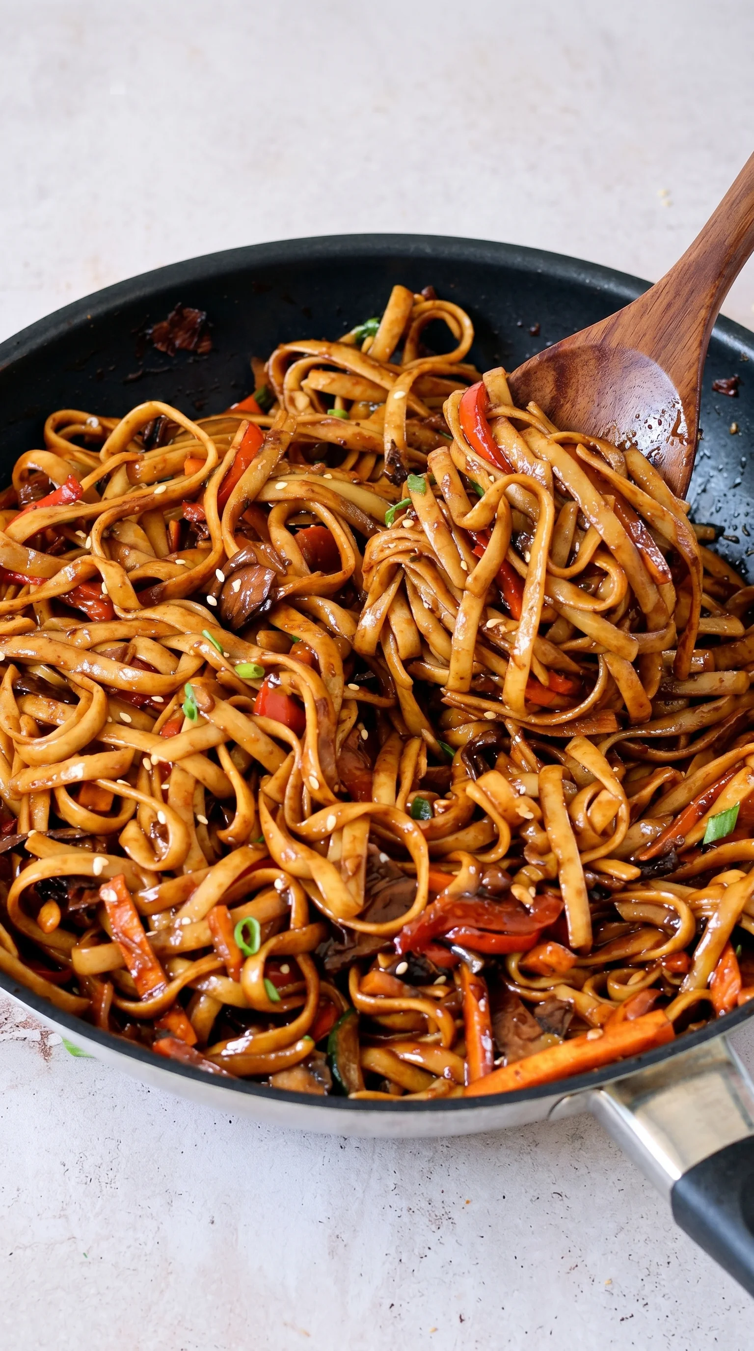 A bowl of noodles with vegetables and meat.