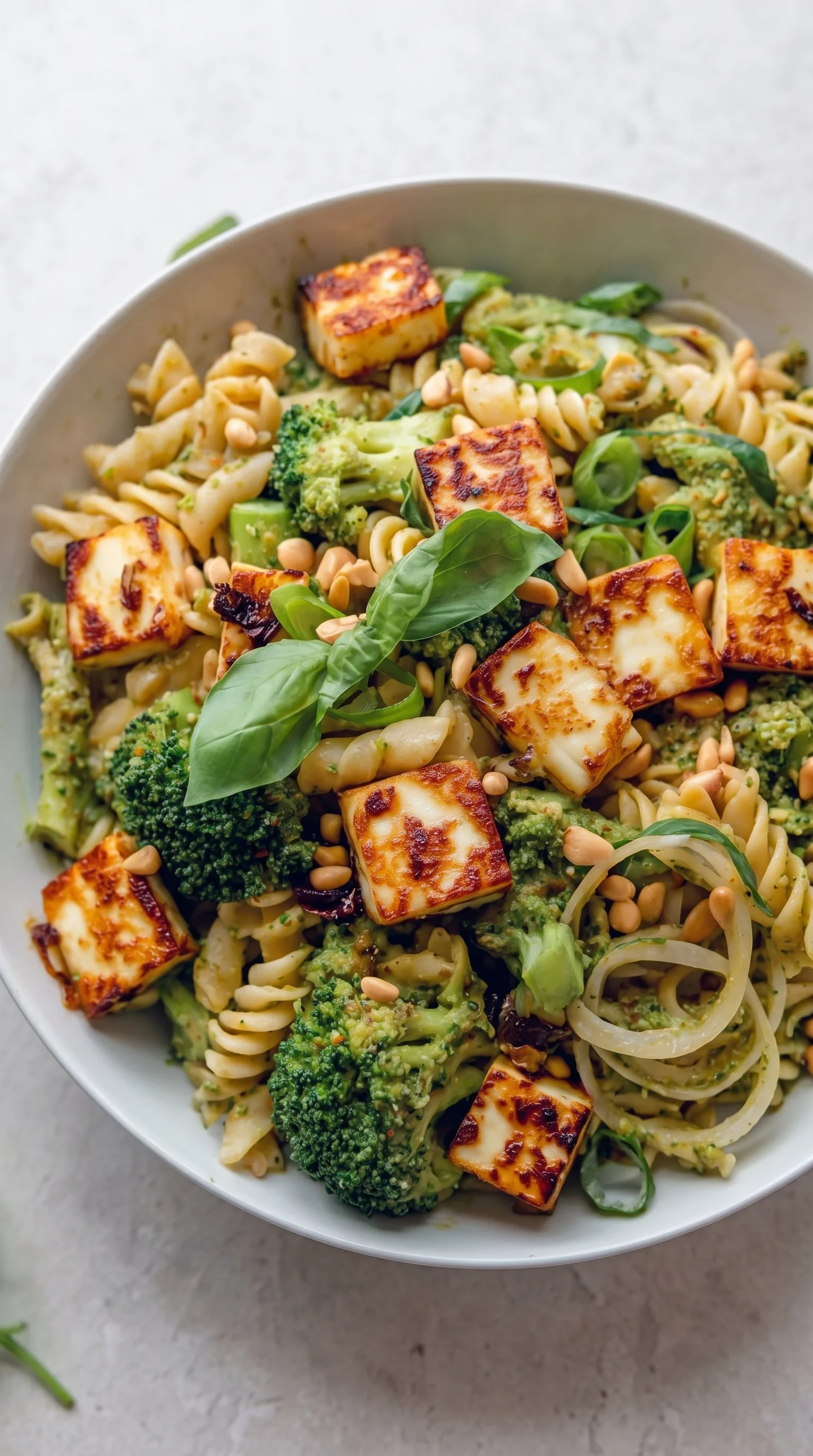 A bowl of pasta salad with broccoli and cheese.