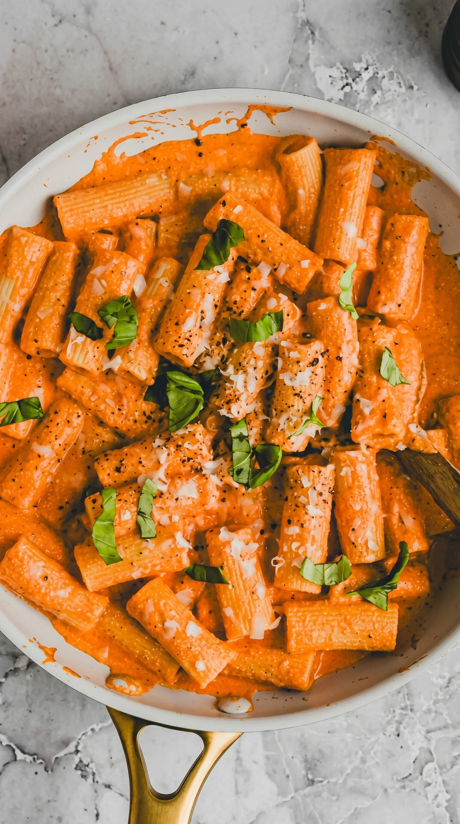 A bowl of pasta with cheese and herbs.