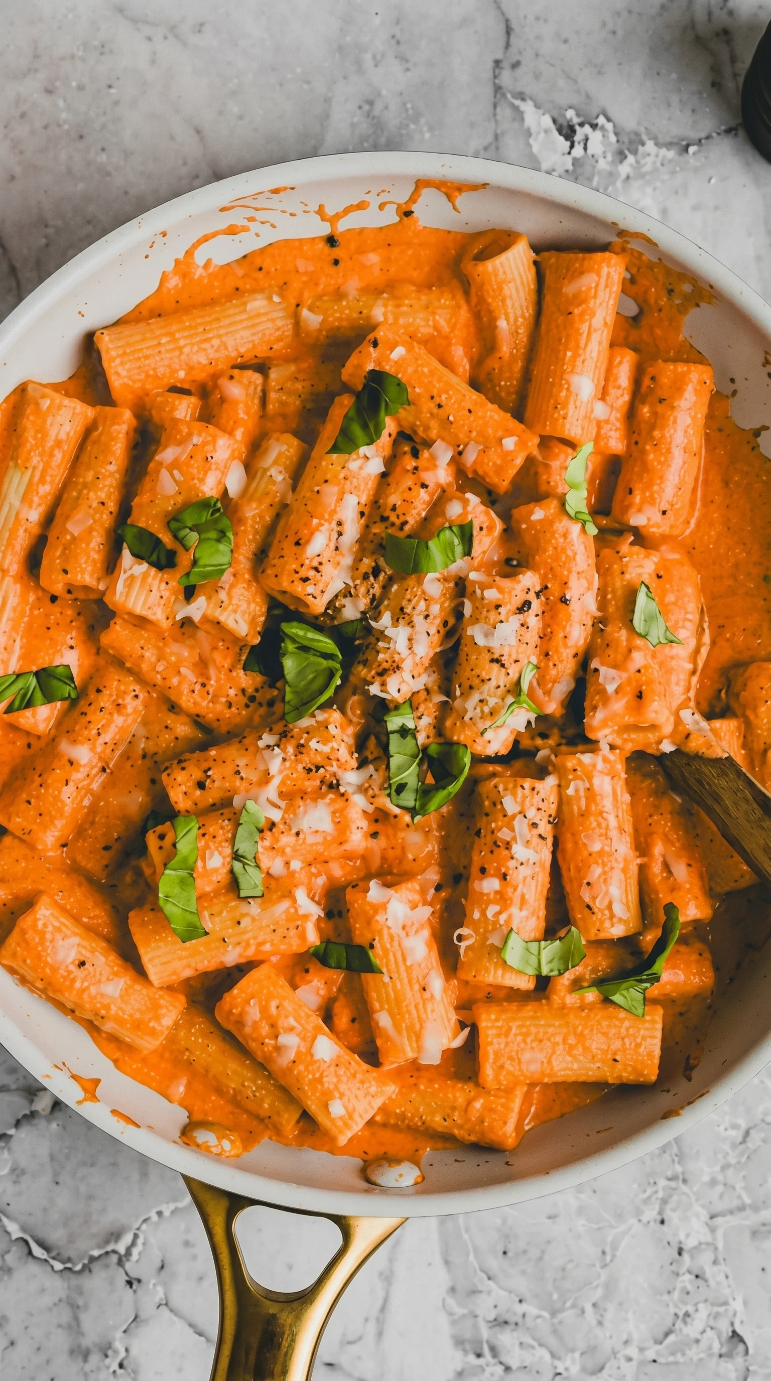 A bowl of pasta with cheese and herbs.