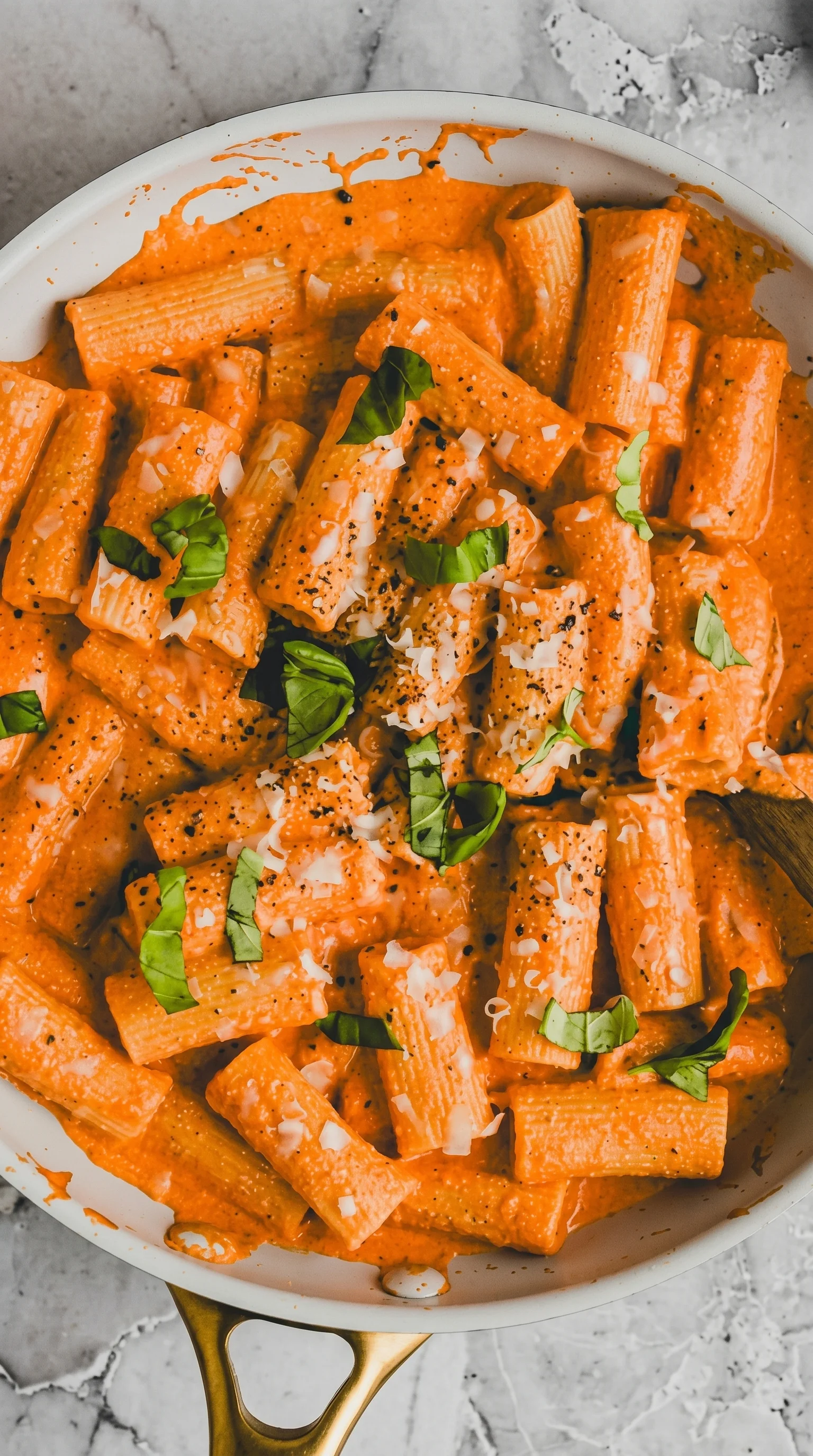 A bowl of pasta with cheese and herbs.