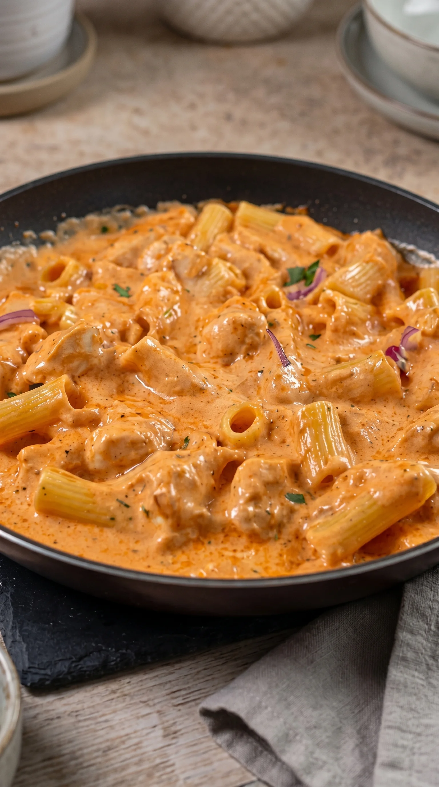 A bowl of pasta with a creamy sauce.