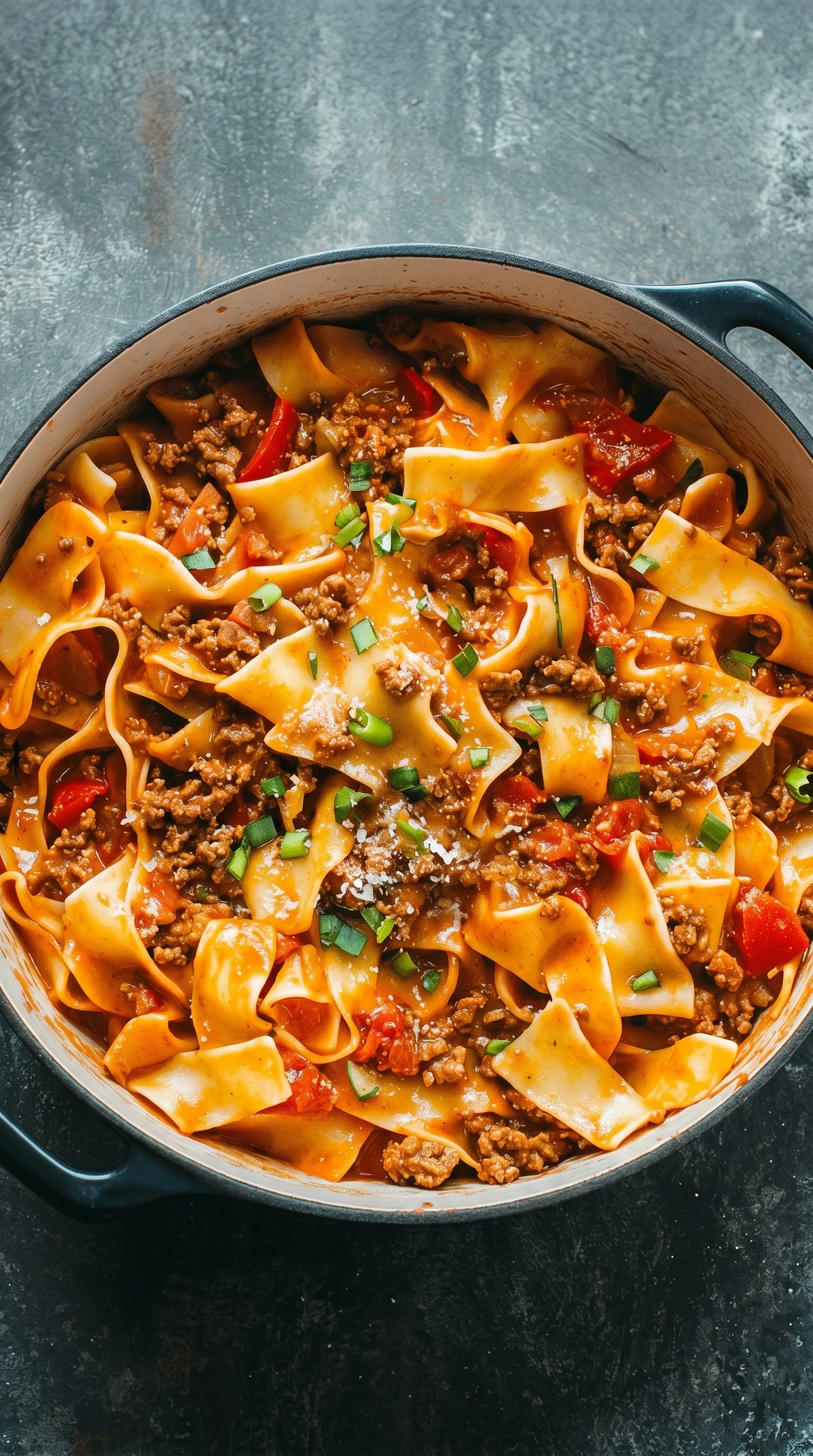 A bowl of pasta with meat and vegetables.