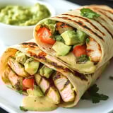 Ein prägnantes Bild von einer Avocado-Lauch-Chicken-Roll mit einer Tomatensauce.